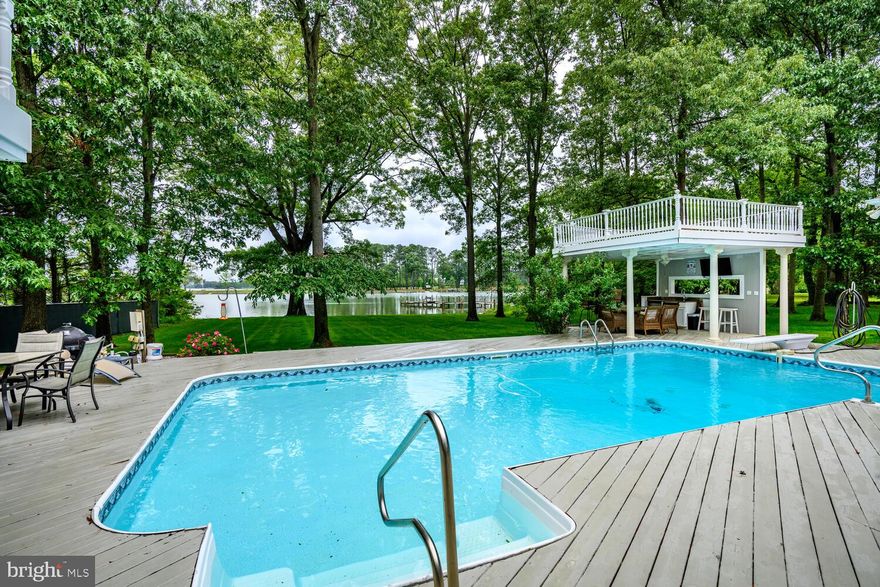 Nestled along the Miles River with westerly sunset views, this exceptional house offers a blend of modern comfort and classic Eastern Shore charm. Boasting sweeping views of St. Michaels, this home features an expansive open floor plan designed for seamless indoor-outdoor living.  Step inside to find a sun-drenched great room creating the perfect setting for both quiet relaxation and lively gatherings. The gourmet kitchen, complete with granite countertops, high-end stainless steel appliances, and a spacious island, flows effortlessly into the living and dining areas, making entertaining a breeze. Outside, the resort-style backyard is an entertainer's dream, highlighted by a sparkling waterside pool, waterside cabana/bar, and lush landscaping. Whether you’re hosting a sunset cocktail hour or enjoying a quiet morning coffee, the panoramic water views provide a stunning backdrop.  Additional features include, whole house generator, detached garage for additional car storage, cedar siding, and an irrigated rear lawn,   a luxurious primary suite with waterfront views, a spa-like bath, generous guest accommodations, and ample storage throughout. With direct water access, you can easily enjoy all the Miles River has to offer. Located just minutes from downtown Easton and a short boat ride to the historic charm of St. Michaels, this property offers the perfect blend of coastal living and small-town sophistication.