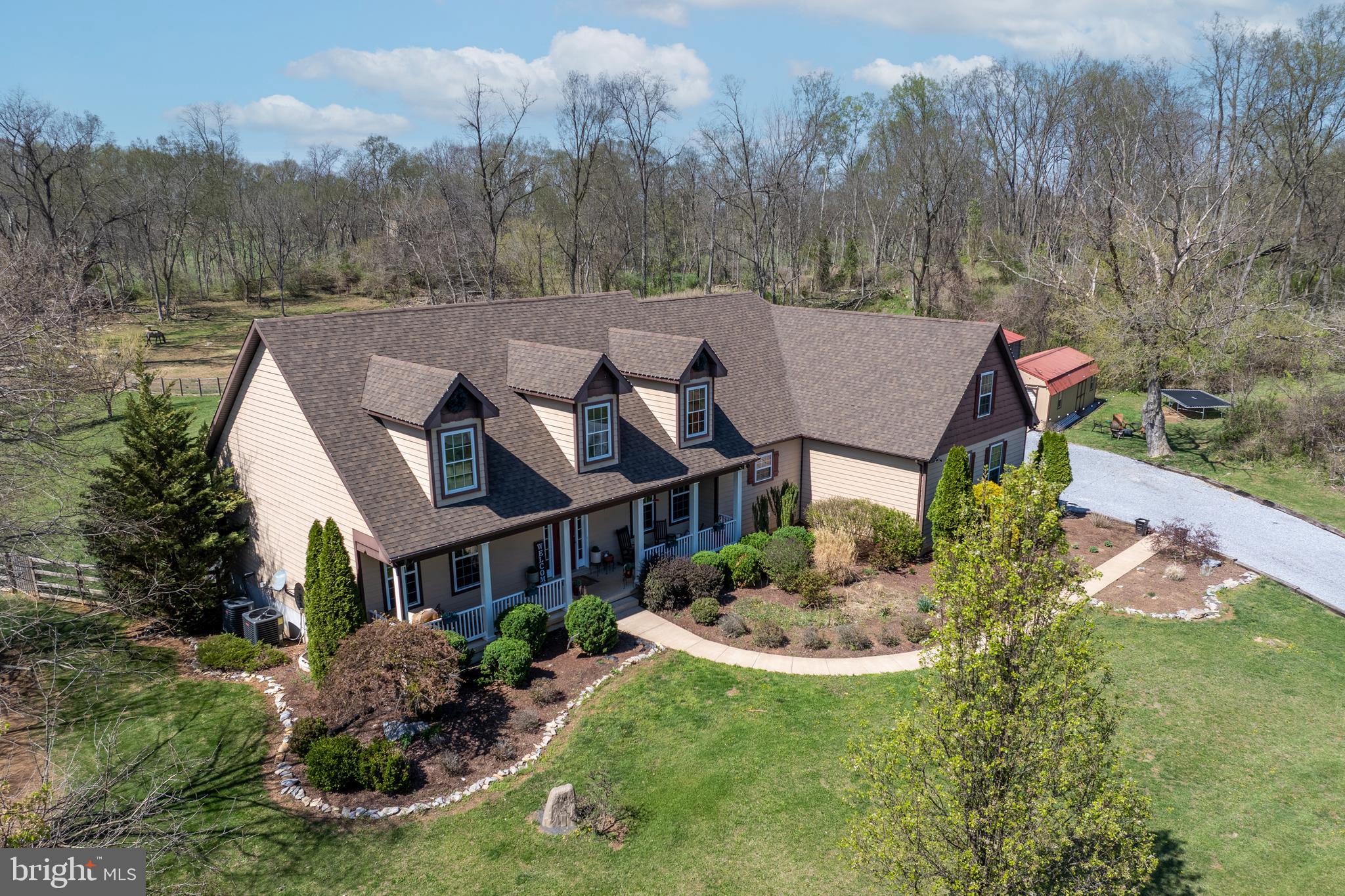 **HUGE PRICE IMPROVEMENT** Tucked at the end of Marsh Hawk Way, you will find a one-of-a-kind custom Cape Cod offering peace, privacy, and stunning pastoral views on 5.27 acres. Built in 2012 with meticulous attention to detail, this 4-bedroom, 4-bathroom, 4,400+ sq ft home is a true retreat for those seeking both luxury and country charm.
From the moment you enter the long driveway, you'll be greeted by a welcoming covered front porch—perfect for sipping coffee and soaking in the mountain air and sunsets. Step inside to find slate flooring, custom built-ins, newly refinished hardwood floors, freshly painted walls, and soaring 10-ft ceilings throughout.
The heart of the home is the spacious family room with a cozy gas fireplace, flowing effortlessly into a gourmet chef’s kitchen featuring granite countertops, custom cabinetry, stainless steel appliances, gas range, wine bar, breakfast nook, and a charming built-in dining area with booth seating. Two large bedrooms on the main level share a full bath with jetted tub.
The primary suite is a private sanctuary with its own expansive deck and hot tub, dual walk-in closets, two full bathrooms (one with a clawfoot tub, the other with a walk-in shower), and a private sitting room or office.
Upstairs offers a large 4th bedroom with en-suite bath and mini split system. Across the hall you will find an amazing rec room designed for entertainment—complete with a pool table, bar, arcade games, theater room, and a versatile bonus room that could easily become a 5th bedroom.
The partially finished walkout basement includes a rough-in for a full bath and kitchenette, wood-burning furnace, egress window, and separate entry—ideal for a potential in-law suite.
Bring your animals! The fenced backyard, fruit orchard, chicken coops, and brand-new 3-stall horse run-in with gates and an 8x12 attached storage room make this house a dream for hobby farmers or equestrians. The new paddock fence is a 4' - 5 wire fence (4 wires are electric) with an electric horse rail top-line. You will also find a 10' gate on 3 sides and a split 12' gate at the front. Tons of storage and functionality abound with an oversized 2-car garage with workshop, single detached garage or RV carport, and a storage shed with roll-up door.
This house has it all - 2x6 construction with composite & shake siding, 50-year architectural shingle roof, owned solar panels, newer HVAC, septic sized for 6 bedrooms, whole-house water filtration system & owned propane tank plus much more!
All this, just minutes from Shepherdstown’s historic charm, Shepherd University, the C&O Canal, Bavarian Inn Resort, MARC train access, and local shopping & dining.
This extraordinary home blends high-end craftsmanship with country living—schedule your private showing today!