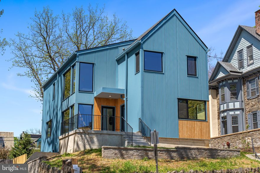 Perched high above and over 50 feet back from West Mt Pleasant Avenue, and offering both stellar serenity and privacy, this 6-bedroom (or 5 bedroom plus office); 4.5 bath home features a spacious family room; substantial outdoor space with multiple outdoor areas; 2-car parking; huge windows for immense light; ideal layout; and a stunning, understated clean modern design.

This ground-up new construction is designed by the renowned C2 Architecture and developed by award-winning Bancroft Green (both local). With the Philadelphia 10-year TAX ABATEMENT, this new construction is anything but cookie-cutter. Rather it offers the tasteful high-end finishes that you would expect to see in such a brilliantly designed custom home. Spectacular, custom, light-filled spaces throughout, including high ceilings; solid white oak flooring; huge European windows of the highest quality (with superb energy efficiency and sound attenuation); cathedral ceilings; and exquisite, contemporary finishes. Multiple-zone ultra-efficient HVAC is complemented by the tight envelope and elevated R-factor (insulation) for premier energy efficiency.

Ample outdoor space, including a large walk-out patio and grass yard off the open kitchen, dining, and living area for perfectly extended indoor-outdoor living and divine entertaining. This patio (and the rest of the home) overlook a beautiful, landscaped property. A balcony off the primary suite also overlooks the back and is perfect for morning reflections. In the front and side, there is a yard, landscaping, and nice patio spaces.

The rear parking generously accommodates two vehicles with a turnaround. Primed for EV charging. The front setback provides ample privacy and buffer from the street. This home offers flexible space for various needs. For example, the lower level and first floor each feature suites, with available connection to the main living spaces as well as a separate exterior entrance—perfect for intergenerational families, a professional office, a main level primary suite, or a den/office/guest room combo. There is a spectacular 2nd floor featuring the primary suite and three additional bedrooms.

As you look through this home with its huge European tilt-n-turn (plus casement functionality) OKNOPLAST® windows, you will not believe you are in the city. Other features include the custom open tread oak stairs with floor to ceiling windows. High ceilings throughout, including pitched, 20-foot ceilings; a 2-story atrium; butler pantry with custom hideaway coffee station; oak floors and excellent storage throughout; custom cabinetry from Studio Cidra (American modern furniture handmade in Philadelphia); and quartz countertops throughout kitchen and all baths, high end appliances as well as 2 wet bars with wine fridges, and 2-zone high efficiency Bosch heat pumps and Broan whole house ERV.

The feel, layout, light, spaces, and finishes of this home are exquisite. Enjoy the most convenient West Mt Airy location--easily walkable to many restaurants, cafes, retail, parks, shopping, library, and more. 5-minute drive to the Wissahickon Valley and miles of wooded trails. Weavers Way Coop and Mt Airy Village. Mt Airy Coffee! 5-minute walk to the SEPTA regional rail. And, of course, a quick ride to Chestnut Hill, Center City, Manayunk, and the Main Line. Live in one of Philly's most desirable and historic neighborhoods. Houston School Catchment (easy walk). 10-year Tax Abatement.