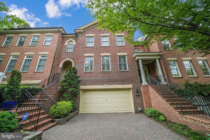 Welcome to this sophisticated Georgian-style townhome, perfectly situated in the exclusive enclave of Mayfair of McLean. This stately, all-brick residence spans three finished levels and features a grand two-story foyer with soaring ceilings and a striking, curved staircase that sets the tone for the refined details throughout.  Enjoy 9–10-foot ceilings and wide-plank Canadian Pine hardwood floors that run throughout the home. Thoughtfully designed custom millwork, built-ins, and architectural trim add character and charm at every turn.  The main level boasts a gracious flow ideal for entertaining while still offering distinct formal spaces.  A spacious formal dining room overlooks the elegant living room, complete with a cozy fireplace and access to a private balcony.  A separate room on this level offers versatility as a home office or peaceful sitting room. The recently renovated chef’s kitchen is a showstopper—filled with natural light and equipped with premium stainless steel appliances, a custom Amish-built cabinet with a marble countertop, and ample space for casual dining. Upstairs, the primary suite serves as a luxurious retreat with a generous walk-in closet and a spa-inspired bath featuring a double vanity, soaking tub, separate shower, and private commode. Two additional spacious bedrooms and a well-appointed hall bath complete this level.  The lower level offers a welcoming family room with a wet bar, perfect for relaxing or entertaining, with direct access to a tranquil private patio and low-maintenance garden. Off the family room is a custom study/library with rich Amish-built bookshelves, ideal for quiet reading or working from home. Also on this level: a laundry room, additional half bath, and interior access to the attached two-car garage. Notable Upgrades and Features Include: Amish-crafted custom kitchen cabinetry and library built-ins, EuroCave wine storage in the garage, central vacuum system, crown molding in primary and lower levels, built-in desk and shelving in lower level, custom plantation shutters, new roof.
Ideally located just 1.5 miles from the West Falls Church Metro, and minutes from Tysons Corner, Arlington, and downtown McLean.  This home perfectly blends classic architecture, modern convenience, and timeless craftsmanship.