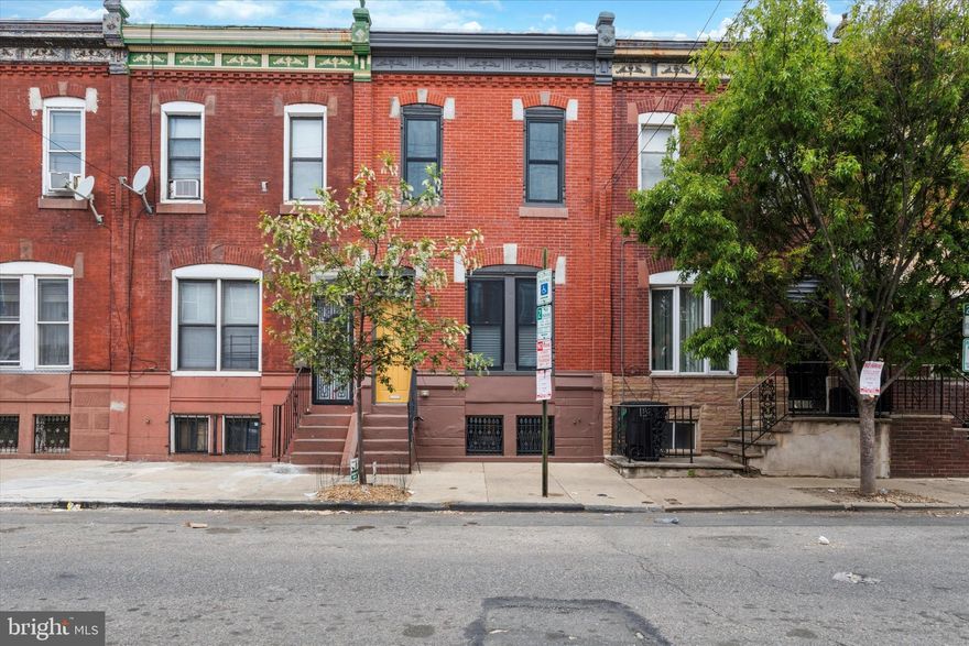 A total dreamboat inside and out, this renovated Point Breeze rowhome is anything but cookie-cutter. The handsome facade has detailed brickwork, a stately cornice and a transom window above the front door, which gives way to a vestibule entrance with original slate tile walls and a main floor with original pine floors that run throughout, super high ceilings and great natural light. The spacious open living/dining room features ceramic Schoolhouse Electric light fixtures and the original staircase with lovely wood banister. The kitchen has an enormous amount of storage space via contemporary Ultracraft white and maple drawers and cabinets that extend to the ceiling, as does the open shelving above the fridge. A salvaged beadboard backsplash and Caesarstone countertops are carried through to the breakfast bar island, which has fun electric blue Muuto pendant lights with quilted LED bulbs and an oversized zero-radius Miseno stainless steel undermount sink with Grohe pulldown faucet. Stainless steel appliances include a Whirlpool five-burner range, dishwasher and microwave, and a Haier French door fridge. This space is nice and bright due to two windows plus a glass door to the downright huge rear yard, which consists of both a large patio and garden bed, plus a bonus side area to stash away bikes, trash cans and gardening supplies. Tucked between the main living space and the kitchen is a powder room with more salvaged beadboard wainscoting, Grohe fixtures and an awesome vintage Beaty American light fixture. The second floor has ample natural light like the first floor, as well as high ceilings and wide-plank original pine floors. The large rear bedroom has two exposures and a nice view of the yard. The middle bedroom has both a standard closet and a second one outfitted with shelves. The spacious primary bedroom at the front gets great southern light and has a big closet and a charming architectural niche. The super stylish hall bath has a full-wall oversized subway tile surround for the Miseno tub with Grohe fixtures and Caesarstone bench seat; the most fun Noga blue and white Moroccan mosaic cement tile floor; and a stylish wall-mounted sink flanked by sconce lighting. There’s storage space and laundry in the full basement. This nice and wide Point Breeze street is just a couple blocks from neighborhood favorites Ultimo Coffee, Hardena cafe and South Philly Taproom, and convenient to tons more dining on nearby Snyder and Passyunk aves.  And as a bonus, there's still plenty of time left on the tax abatement.