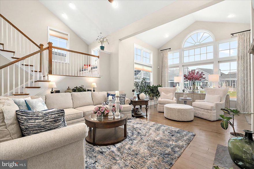 Introducing 19218 American Holly Road – Location, location, location! It is a unique opportunity when a Rehoboth Beach home nestled between open community space and a tree lined pond in the sought after Arbor Lyn community becomes available. Come and see this 5400+ square foot meticulously maintained 5 bedroom, 5 bathroom home. 19218 American Holly Road is Schell's popular Lilac model. In addition to being one of the most desirable floor plans and situated on a premium lot, the numerous upgrades selected during construction—along with the enhancements added by the current owners (list available)—make this home a true standout. From the moment you arrive the curb appeal draws you up to the spacious covered front porch. Once inside, the capacious foyer provides a seamless flow past an office/den, powder room, laundry room with access to the two car garage and into the stunning fully upgraded kitchen, open dining and soaring great room with vaulted ceilings, cathedral style windows and a floor-to-ceiling stone gas fueled fireplace with a raised hearth. The kitchen and dining room are impressive with top end appliances and finishes perfectly designed to welcome the gathering of your family and friends. Seamless wood floors throughout the main level lead to a first floor primary suite that enjoys views out to the pond and is fully separated from the upstairs guest rooms providing total privacy for you and your family or guests. The four large upstairs bedrooms include a second primary suite featuring a large walk in closet and beautiful ensuite bath. A private covered porch off the second floor primary has pond views.  A second full upstairs bath serves the other three guest rooms. The second floor also features an open concept loft dramatically overlooking the living room below where you will find yourself lingering in late afternoon as western sunlight floods through a large plate glass window providing stunning horizon views of sunsets. Downstairs off the sunroom extension of the living room is an enclosed three season porch which leads to a large paver patio, a gas hookup on the patio is ready for your summer grilling goals. From the three season room or patio you will appreciate seeing the inspiring wildlife and seasonal foliage that border the tranquil pond throughout the year. One of the most exciting spaces in the house is the fully finished lower level featuring a stunning wet bar with ice machine and custom cabinetry to host even the largest gatherings. The lower level also features a gorgeous movie room with insulated paneled walls and ready-to-go electronic hook ups for your choice of viewing experiences. There is a one half bath and two large storage rooms with plenty of shelving that conveys to complete the lower level. Perfectly located just minutes from Rehoboth Beach and boardwalk, you’ll enjoy easy access to everything! When you choose to stay close to home and spend time with your friendly neighbors you'll be glad that Arbor Lyn offers resort-inspired amenities including a pool and clubhouse with outdoor fireplace. This exceptional home presents a rarely available ready made opportunity of real value. At only $194 sq foot there simply is no better deal in Rehoboth Beach! Rentals of 7 days or more are permitted. Nearly brand new top end home furnishings could also be included in sale. The complete list of upgrades and improvements is available for review. The house is under a transferable warranty. Whether you're seeking a luxurious family home or a convenient coastal getaway, this well located property truly has it all.