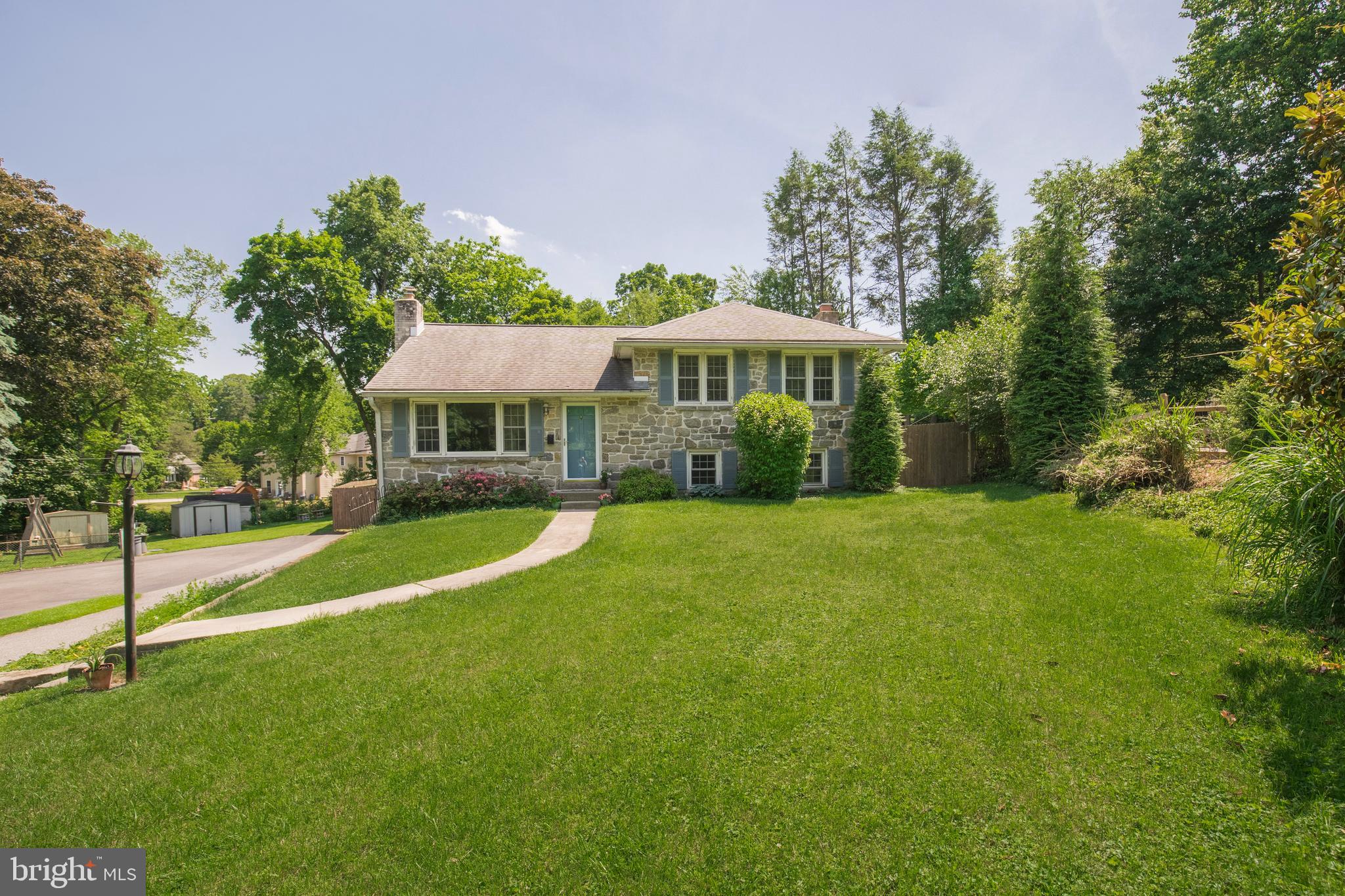 This classic stone split level is hidden on a peaceful cul-de-sac in the coveted Wallingford Swarthmore School District. With access to Septa Regional Rail and Swarthmore's charming downtown just steps away, this home is Philly suburban living at its finest! Enter the lovely stone facade to find a formal living area/ music room with an expansive bay window and gleaming original hardwood floors, found throughout the home. Just beyond is the dining area with open access to the updated kitchen. The kitchen was updated in 2015 with granite counters, stainless appliances, and additional storage. An adjacent family room, also added in 2015, creates the perfect open concept living environment. The family room is highlighted by a multitude of windows to enjoy serene views of the private yard. French doors lead to a deck and an expansive fenced yard. The lower level features a stunning stone gas fireplace, wet bar, and plenty of room for family fun, parties, or remote work/learning. Another level below features a laundry room with built in cedar closets, and both garage and exterior access. A primary bedroom, flanked by two generous sized bedrooms and a hall bath complete the upper level of the home. Take advantage of this home on a rarely available street in the award winning Wallingford-Swarthmore schools!