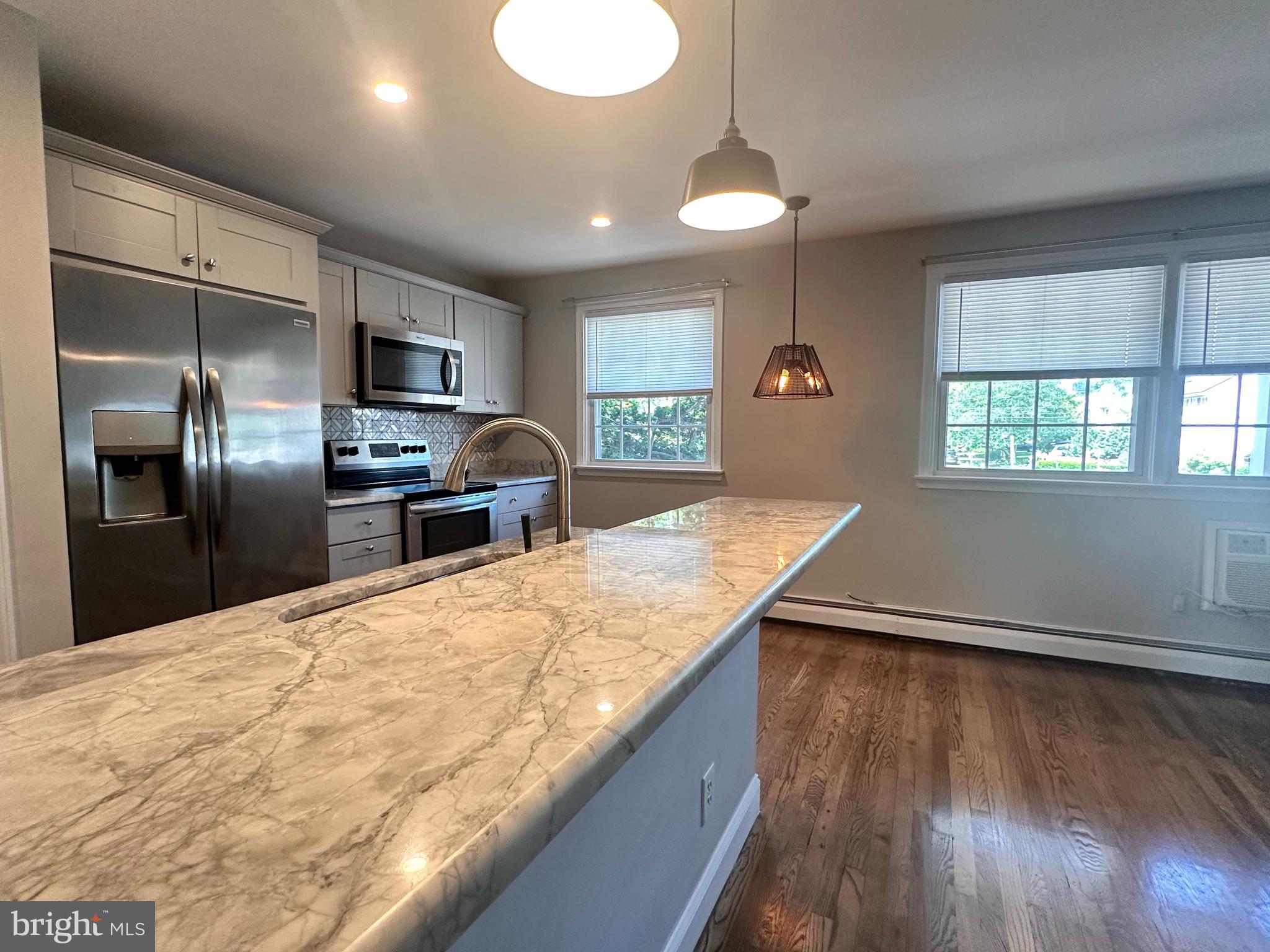 Beautifully renovated 2-bedroom, 1-bath apartment in Doylestown Borough—offered for the first time as a rental. Features include hardwood floors throughout, high-end granite countertops, stainless steel appliances, and an updated bathroom with designer touches. A stylish barn door separates the main living space from the bedroom wing for added privacy and charm. The spacious primary bedroom includes two closets. In-unit washer and dryer with bonus storage shelving. Walkable to shops, dining, and cultural attractions in the heart of the Borough. A rare opportunity to enjoy modern finishes and Borough living in one.