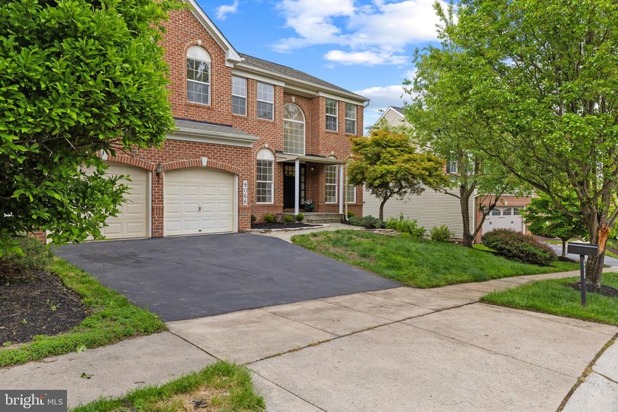 Elegant brick Colonial nestled in desirable Autumn View, showcasing extensive hardscaping with a curved stone retaining wall, lush landscaping, and impressive curb appeal that immediately sets the tone. Inside, discover 3,724 finished square feet featuring a traditional floor plan, rich wood flooring, oversized windows, custom window treatments, abundant natural light, and a neutral color palette throughout.

The welcoming two-story foyer with hardwood floors is flanked by a formal living room with plush carpeting on one side and a formal dining room on the other, accented by lower wainscoting and classic chair railing. The open-concept great room is designed for both comfortable everyday living and entertaining, featuring a spacious carpeted family room with a cozy wood-burning fireplace. Adjacent to the family room is a bright breakfast area with exterior access and the eat-in kitchen.

The kitchen offers upgraded countertops, a center island with bar seating, a built-in writing station, sleek black appliances, shaker-style cabinetry, and a pantry for added storage and functionality. Nearby, you’ll find a convenient powder room, laundry room, and a versatile bonus room ideal for a home office, library, guest room, or additional bedroom to accommodate flexible living needs.

Upstairs, the upper level features five carpeted bedrooms and two full bathrooms. The expansive primary suite is highlighted by vaulted ceilings, a large walk-in closet, and a private ensuite bath complete with a dual sink vanity, soaking tub, and separate shower. Three of the additional bedrooms also include walk-in closets.

The finished lower level provides even more living space with a recreation room centered around a fireplace and a kitchenette featuring built-in wine storage, a breakfast bar, and ample cabinetry. A versatile bonus room and a spa-inspired full bathroom with a modern shower and sauna complete the level.

Outdoor living is equally inviting with a large deck that steps down to a partially covered stone patio framed by a curved retaining wall and additional outdoor storage.

Residents of the community enjoy an impressive array of amenities including walking trails, a clubhouse, fitness center, salon, convenience store, day care, tennis courts, tot lots and playgrounds, as well as three outdoor pools featuring a baby pool, kiddie pool with a water feature, and a standard swimming pool. Select photos include virtual staging for illustrative purposes only.