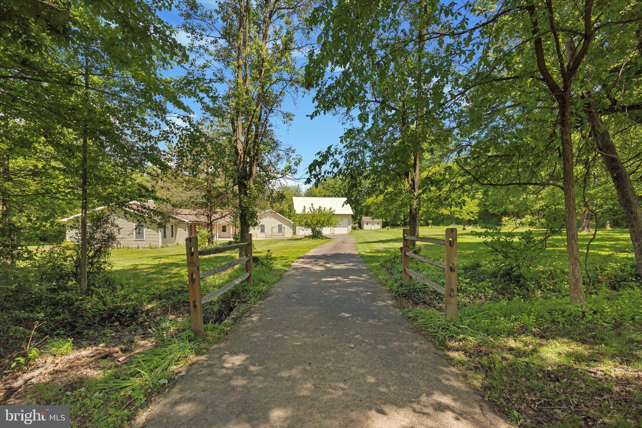 Rarely offered - Custom built ranch set on over 13 acres of pristine, private land offering unmatched serenity and stunning country views. Spacious great room with wood burning stove and French doors leading to your own private backyard retreat. A large country chef-inspired gourmet kitchen with a separate breakfast room perfect for large family meals. A formal dining, beautiful primary suite with private bath, two generously sized additional bedrooms and a full bath featuring both a tub and a separate stall shower for added convenience. A private entrance on the opposite side of the home opens to spacious bonus rooms offering endless possibilities perfect for a guest suite, studio, in-law suite or extended family living. Special feature includes whole house generator and central vac system. Bring your vision - the home is ready for new flooring and finishes to reflect your personal style. Enjoy the wide-open space complemented by an impressive pole barn/shop featuring 7-bays with lift and storage on the second floor ideal for automotive professionals or serious enthusiasts. A separate multi-purpose building ideal for a workshop, music or art studio, hobbyist or home business. You'll appreciate the on-site shed perfect for storing all your landscaping tools and outdoor equipment. Truly one-of-a kind home being sold as-is. Seller will make no repairs or concessions.