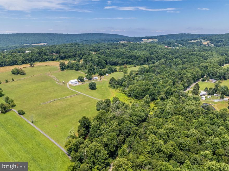 Beautiful and fruitful farm in Frederick county.  Almost 80 acres of tillable, hay producing, fertile land with appropriate space and design for cattle and other livestock.  A quaint 2 bedroom - 1 bathroom farm house sits perched on a knoll on the West side of the property.  The understated comfortable home has a full attic, a full basement with a cellar and potato bin.  The oil burner is  newer and so is the hot water heater.  Large mature trees dance in the ever constant gentle breeze most appreciated from the sitting porch which is also under cover.  In our minds, it's the perfect bean snapping spot where stories are told and lessons are learned.  There is a detached garage, an equipment shed and a large bank barn with stalls.   The floor, old original beams and structure appear to be in excellent condition. This property has a creek that runs along its boundary that runs healthy all year long.  Most notable are the man-made stone fence line walls dividing paddocks and pasture that pull your attention to the old way of life the second you pull into the farm.   They are a stunning sight.   You'll have to cross the bridge over the creek to wind your way into this special well- loved farm and once you do, you may just not ever leave.  Ag preservation estimates are available as well as tillable estimates.  The family has proudly maintained this gorgeous homestead where Hereford beef cattle once roamed.  They have a strict as is, where-is, in place.  Middletown school district.