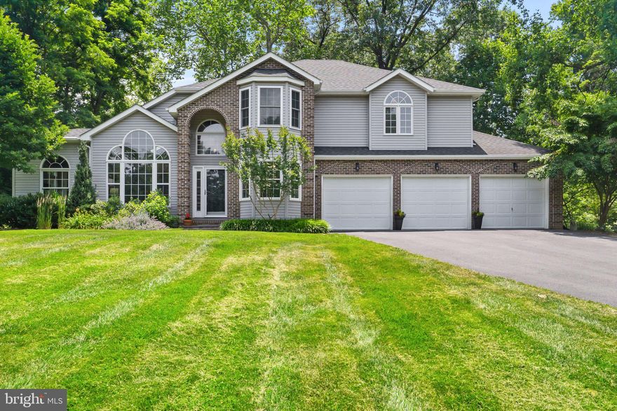 Before even entering this elegant home, you know you’re looking at something special. The handsome brickwork combined with unique architectural features holds promise—that delivers. And sitting on five unblemished acres, against a backdrop of mature hardwoods and attractive landscaping, it provides significant privacy. But it’s everything inside that both surprises and pleases. Greeted by cathedral ceilings,
oversized windows, bright hardwood floors, and contemporary paint, this floor plan is a breath of fresh air. Step down into a living room with plenty of space for furniture and a fetching wall of usable built-in shelves and cabinets. The central staircase offers a touch of whimsy with its chalkboard side perfect for kid or adult games—or your message of the day. The dining area pleases with a view of the great outdoors and space for a formal table plus standalone pieces—and even has an adjacent mini-counter where you
could snack or work. Enter the tile-floored kitchen with plenty of cabinets, a cooktop island, double oven, and butcher-block style open shelf units. You won’t lack for storage or counterspace in this gourmet kitchen. Transitioning seamlessly to the cozy family room, with space between for a casual dining set-up, you reap additional lounge space, with a gas fireplace anchoring one wall and big glass doors leading to a back deck outside. A half-bath, extra room (perfect for an office), and mud or laundry room with access to the three-car garage round out this level. The four bedrooms and two full baths are upstairs. The primary bedroom wows with its generous space, window seat, walk-in closet, and spectacular en suite bath with gorgeous tilework, a sunken tub, separate shower, and a double vanity with abundant storage. The other three bedrooms come in welcome sizes with dedicated closet space. Head outside to enjoy your deck and the bricked patio in your lush garden and natural oasis. There’s even a basketball court off the driveway.
This is a must-see if you long for a spectacular house with elbow room while still having a Winchester address.