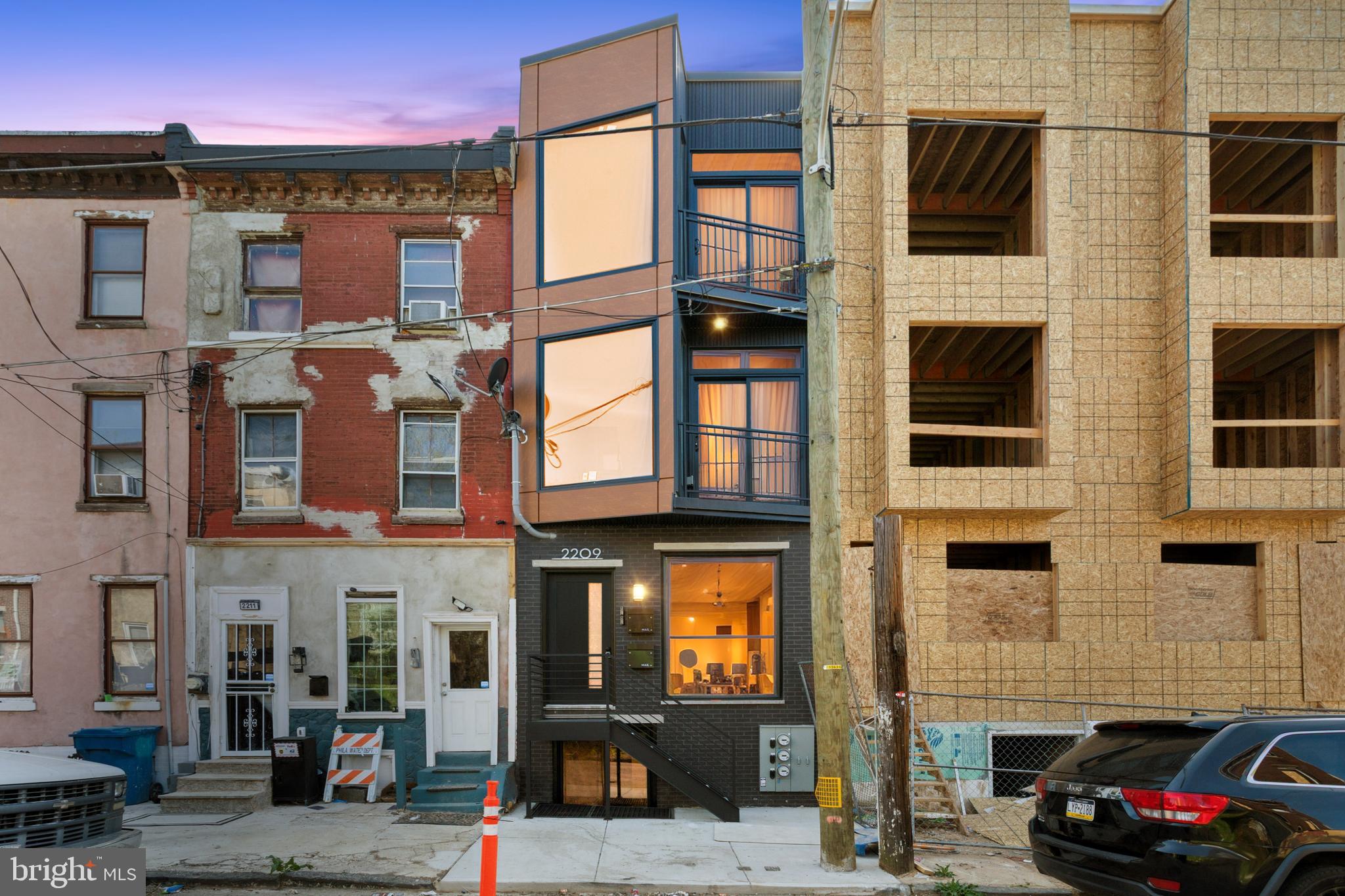 Welcome to 2209 N Franklin Street, a beautifully designed, architecturally distinctive duplex that stands out with its bold modern façade, oversized windows, and sleek lines that bring a fresh, contemporary feel to the block in Philadelphia’s rapidly developing Temple neighborhood. Thoughtfully designed with both luxury and function in mind, this property offers two distinct units: a 2-bedroom, 2-bathroom unit with private backyard access and a 3-bedroom, 2-bathroom unit featuring a spacious private roof deck. This is the perfect opportunity for house owner-occupants looking to live in style while offsetting their mortgage with rental income. Live in one unit and rent out the other to help cover monthly expenses—while building equity in a beautifully finished, income-producing property. Inside, you’ll find high-end finishes throughout: wide-plank flooring, granite countertops, soft-close wood-grain cabinetry, and full stainless steel appliance packages. The kitchens are modern, functional, and designed for everyday living, while the bathrooms impress with dramatic floor-to-ceiling emerald green tile work, frameless glass showers, and custom vanities. Large windows flood the space with natural light, and generous closet space adds everyday convenience. Both units include central air, recessed lighting, washer/dryer hookups, and sleek modern details that elevate the living experience. The lower unit offers a private backyard retreat, while the upper unit’s rooftop deck delivers panoramic views, both rare features that increase the rental appeal of each unit. As a new construction property, this home also comes with Philadelphia’s tax abatement, offering significant savings over the next 10 years and making it an even smarter investment. Conveniently located near Temple University, public transportation, Broad Street, and major commuting routes, 2209 N Franklin is well-connected to everything the city has to offer. The temple neighborhood is experiencing rapid revitalization with new construction, local business growth, and strong community investment—making this an ideal time to buy in. Whether you're an investor or a buyer ready to house hack your way into homeownership, this duplex checks all the boxes: location, design, income potential, and long-term value.