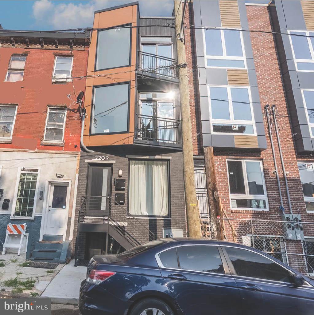 Welcome to 2209 N Franklin Street, a beautifully designed, architecturally distinctive duplex that stands out with its bold modern façade, oversized windows, and sleek lines that bring a fresh, contemporary feel to the block in Philadelphia’s rapidly developing Temple neighborhood. Thoughtfully designed with both luxury and function in mind, this property offers two distinct units: a 2-bedroom, 2-bathroom unit with private backyard access and a 3-bedroom, 2-bathroom unit featuring a spacious private roof deck. This is the perfect opportunity for house owner-occupants looking to live in style while offsetting their mortgage with rental income. Live in one unit and rent out the other to help cover monthly expenses—while building equity in a beautifully finished, income-producing property. Inside, you’ll find high-end finishes throughout: wide-plank flooring, granite countertops, soft-close wood-grain cabinetry, and full stainless steel appliance packages. The kitchens are modern, functional, and designed for everyday living, while the bathrooms impress with dramatic floor-to-ceiling emerald green tile work, frameless glass showers, and custom vanities. Large windows flood the space with natural light, and generous closet space adds everyday convenience. Both units include central air, recessed lighting, washer/dryer hookups, and sleek modern details that elevate the living experience. The lower unit offers a private backyard retreat, while the upper unit’s rooftop deck delivers panoramic views, both rare features that increase the rental appeal of each unit. As a new construction property, this home also comes with Philadelphia’s tax abatement, offering significant savings over the next 10 years and making it an even smarter investment. Conveniently located near Temple University, public transportation, Broad Street, and major commuting routes, 2209 N Franklin is well-connected to everything the city has to offer. The temple neighborhood is experiencing rapid revitalization with new construction, local business growth, and strong community investment—making this an ideal time to buy in. Whether you're an investor or a buyer ready to house hack your way into homeownership, this duplex checks all the boxes: location, design, income potential, and long-term value.