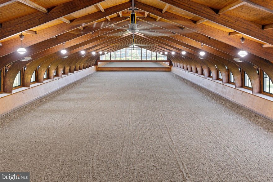 Rarely… does such a unique, well-designed, constructed, and maintained world-class equestrian facility grace the international real estate market. Spanning 510 preserved acres, this iconic equestrian estate boasts a rich legacy and unparalleled amenities, including a state-of-the-art equestrian training facility built by B&D Builders, a nationally renowned custom builder. RiverEdge Farm is synonymous with world-class equestrian training, ideally suited to any discipline. The farm has previously housed numerous Olympic dressage and three-day event horses, operated as a top-class private thoroughbred breeding facility, and most recently served as a training mecca for world-class dressage. At the heart of the property is a spectacular 31-stall, 45,000-square-foot indoor dressage show barn. Built with unmatched craftsmanship and old-world charm second to none. Visitors are welcomed through a charming, covered porch and elegant, glass-paneled double doors into a grand reception area featuring a central stone fireplace and a private meeting room, all adorned with custom millwork throughout. Overlooking the 100’ x 200’ indoor dressage arena are stunning glass-enclosed observation areas on both the first and second floors, that are brilliantly filled with natural light and character. This impressive space includes twin service bars, a conveniently located commercial-grade kitchen, and a spacious area ideal for entertaining. An ornate wide-plank staircase leads to a lofted second level with private office suites, an exercise room, and a lounge area. The barn itself is thoughtfully designed, featuring barreled ceilings, six grooming/wash stalls, two well-appointed tack rooms, a central eat-in kitchen/break area, a laundry room, and a three-season sitting room offering panoramic views through grand window walls on two sides. The barn’s layout seamlessly flows through a bank of 31 spacious (mostly 14’ x 14’) stalls, curving into an additional wing with even more accommodations. Complementing the equestrian facilities is a beautifully appointed 9,000-square-foot brick manor home of Georgian architectural style, offering five bedrooms and 3 full & 2 half bathrooms. This wonderful home features an updated kitchen, brick and antique wood flooring, beamed ceilings, a sunken living room, multiple fireplaces, a spacious game room, and a detached three-car garage. The extensive grounds are thoughtfully and professionally landscaped. It artfully blends traditional character with modern conveniences—perfectly suited for today’s lifestyle. Also included within this breathtaking property is a luxurious guest home featuring a chef’s kitchen and an enclosed timber-framed pavilion over a heated indoor pool. Additionally, there is a 15-stall center-aisle block barn with a six-horse Kraft Eurocizer, as well as numerous ancillary operational buildings, including a fully functional brick office building—and numerous double-fenced fields and paddocks with approximately 10 miles of four-rail post-and-board fencing offering unparalleled views throughout the farm. RiverEdge is set within one of Maryland’s largest agricultural preservation areas and is protected by a conservation easement, ensuring its beauty and legacy for generations to come. The property includes 4 parcels: 0802016206 - 109.4 acres, 0802019078 - 186.7 acres, 0802029049 - 106 acres, and 0802029537 - 109.4 acres. The property is co-listed by Patterson Schwartz Land & Farm Division & Monument Sotheby's International Realty.