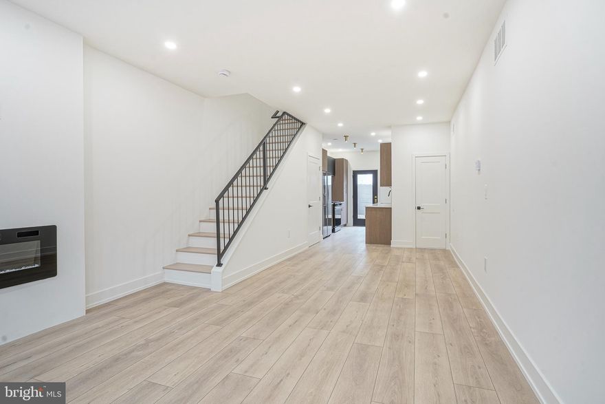 Welcome to 1115 Fitzgerald Street, a beautifully renovated home offering modern finishes and an unbeatable location! Step inside to find an open and inviting living area featuring brand-new vinyl flooring throughout and a built-in electric fireplace that adds warmth and style. The sleek galley kitchen boasts custom wooden cabinetry, new appliances, custom counter to wall quartz with ample counter space—perfect for everyday cooking or entertaining. A convenient powder room completes the first floor. Upstairs, you’ll find two spacious bedrooms with generous closet space. The primary suite includes a private full bathroom with stunning floor-to-ceiling tile and a contemporary vanity. The second full bathroom is also beautifully tiled into the  shower. Laundry is made easy with washer and dryer hookups located on the second floor. The finished basement offers additional living space—ideal for a home office, gym, or media room. Step outside to a private backyard with a large flower bed, perfect for entertaining or relaxing outdoors. Situated in a prime South Philly location, this home is just a short walk to the sports complexes, Philly Live! Casino, and vibrant Passyunk Avenue. Enjoy easy access to public transportation, major highways (I-95, I-76, and the Walt Whitman Bridge), and the airport. Move right in and enjoy modern city living at its finest!