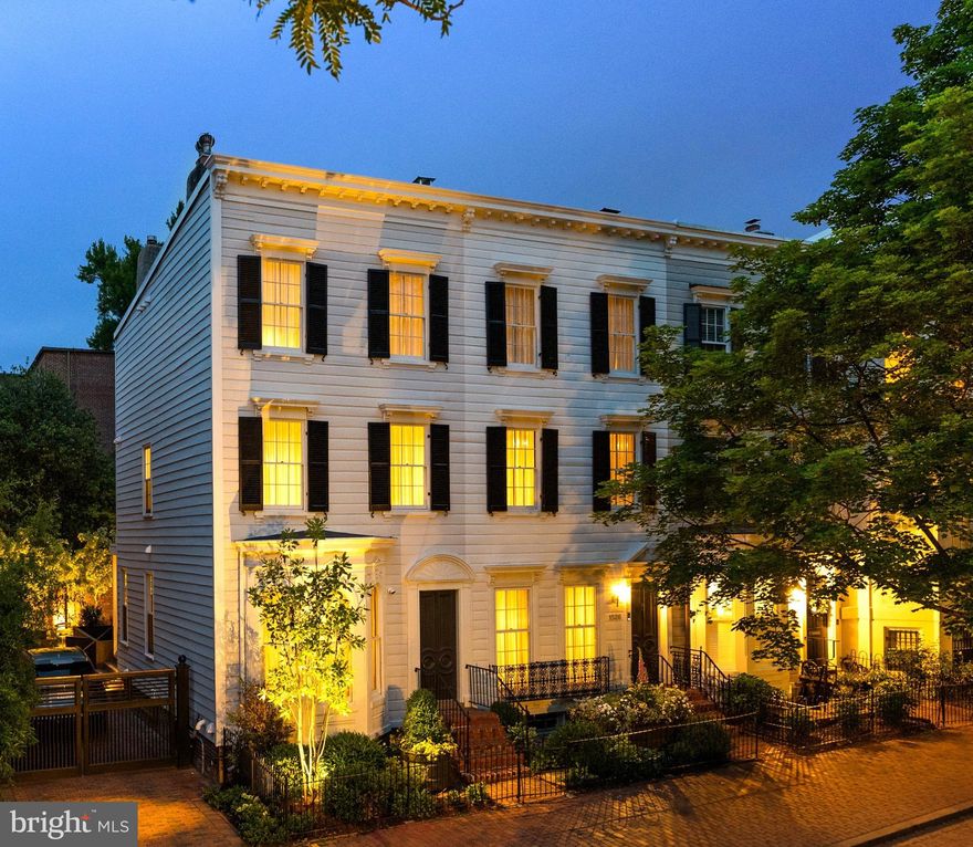 Behind the historic façade of two late 19th-century Federal rowhomes lies a truly exceptional Georgetown residence, thoughtfully reimagined into a singular approximately 5,000-square-foot home that seamlessly blends preserved architectural character with contemporary design.

Formal and informal living spaces unfold with remarkable scale and flow, featuring original fireplaces, arched openings, custom millwork, and curated architectural detailing throughout. Steel-framed windows and doors at the rear of the home flood the interiors with natural light and open to a beautifully enclosed Parisian-style garden, offering rare privacy and tranquility in the heart of Georgetown.

The primary suite occupies its own private retreat-like level with generous proportions, custom built-ins, and integrated security features including a ballistic-rated steel core door, reinforced locking system, and carbon fiber-reinforced walls.

A dedicated wellness level includes a fully integrated gym, sauna, and cold plunge — an extraordinary amenity package rarely found in historic Georgetown homes.

Rebuilt in its entirety, the residence balances historic preservation with modern livability at the highest level. Additional features include gated two-car parking, extensive custom lighting and millwork, and thoughtfully integrated smart home and security systems. A rare offering combining scale, privacy, wellness, and contemporary luxury within one of Georgetown’s most coveted settings.