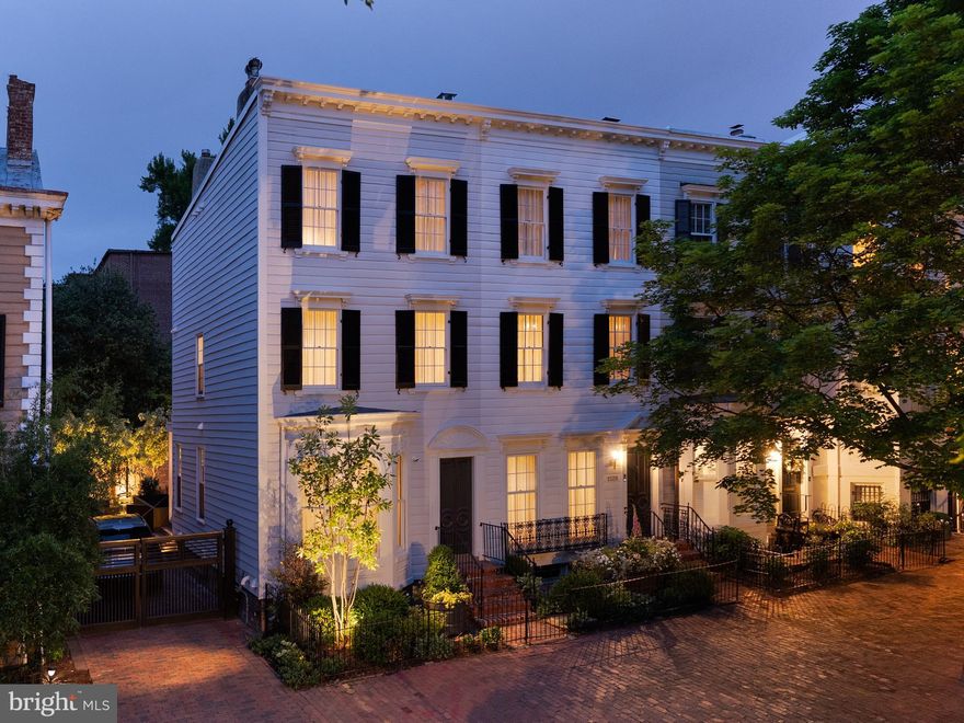 Behind the historic façade of two late 19th-century Federal rowhomes lies a truly exceptional Georgetown residence, thoughtfully reimagined into a singular approximately 5,000-square-foot home that seamlessly blends preserved architectural character with contemporary design.

Formal and informal living spaces unfold with remarkable scale and flow, featuring original fireplaces, arched openings, custom millwork, and curated architectural detailing throughout. Steel-framed windows and doors at the rear of the home flood the interiors with natural light and open to a beautifully enclosed Parisian-style garden, offering rare privacy and tranquility in the heart of Georgetown.

The primary suite occupies its own private retreat-like level with generous proportions, custom built-ins, and integrated security features including a ballistic-rated steel core door, reinforced locking system, and carbon fiber-reinforced walls.

A dedicated wellness level includes a fully integrated gym, sauna, and cold plunge — an extraordinary amenity package rarely found in historic Georgetown homes.

Rebuilt in its entirety, the residence balances historic preservation with modern livability at the highest level. Additional features include gated two-car parking, extensive custom lighting and millwork, and thoughtfully integrated smart home and security systems. A rare offering combining scale, privacy, wellness, and contemporary luxury within one of Georgetown’s most coveted settings.