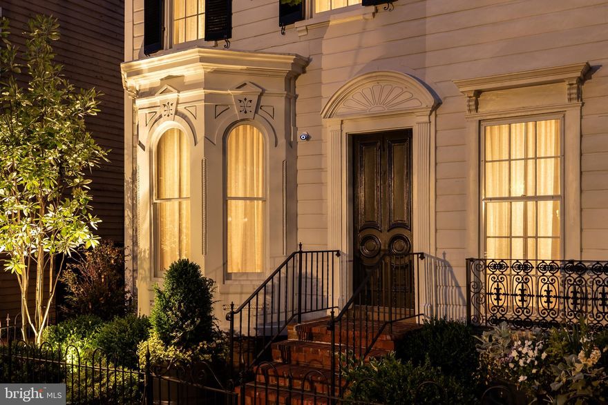 Behind the historic façade of two late 19th-century Federal rowhomes lies a truly exceptional Georgetown residence, thoughtfully reimagined into a singular approximately 5,000-square-foot home that seamlessly blends preserved architectural character with contemporary design.

Formal and informal living spaces unfold with remarkable scale and flow, featuring original fireplaces, arched openings, custom millwork, and curated architectural detailing throughout. Steel-framed windows and doors at the rear of the home flood the interiors with natural light and open to a beautifully enclosed Parisian-style garden, offering rare privacy and tranquility in the heart of Georgetown.

The primary suite occupies its own private retreat-like level with generous proportions, custom built-ins, and integrated security features including a ballistic-rated steel core door, reinforced locking system, and carbon fiber-reinforced walls.

A dedicated wellness level includes a fully integrated gym, sauna, and cold plunge — an extraordinary amenity package rarely found in historic Georgetown homes.

Rebuilt in its entirety, the residence balances historic preservation with modern livability at the highest level. Additional features include gated two-car parking, extensive custom lighting and millwork, and thoughtfully integrated smart home and security systems. A rare offering combining scale, privacy, wellness, and contemporary luxury within one of Georgetown’s most coveted settings.