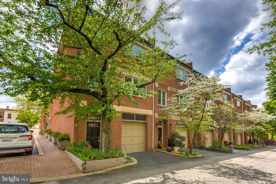Located on a secluded tree lined lane in the middle of Federal Hill, this meticulously maintained end-of-row garage townhome in private and quiet Grindall’s Yard has everything today's buyers are seeking. With a premier location in the community, the home enjoys Northern, Eastern, and Southern exposures and is filled with light. In addition to the garage there is a reserved parking space across the lane along with 2 visitors spaces.  The entry level offers a one car garage with plenty of loft storage space and built-ins. Continue through the foyer to a large family room/den/office with a wet bar and access to the shaded patio with built-in charcoal BBQ grill and storage. The versatile lower level basement can serve as a recreational room, media room and for additional storage. With multiple skylights there is no shortage of natural light throughout the neutrally painted home. The eat-in kitchen features corian counters, a peninsula bar and breakfast area, and a powder room. The dining and living rooms have beautiful custom built-ins and bookcases, recessed lighting, a wood-burning fireplace and access to an incredible sunny balcony with views over a quiet neighborhood mews. Continue up the staircase to the primary bedroom suite with French doors overlooking the bright south facing exterior.  This suite features a large walk-in closet and full bath.  There are two more bedrooms with an adjoining hall bath.  Bonus! The laundry is conveniently located in one of the upper level bedroom closets. With over 2500 finished square feet, multiple exterior living spaces, access to a gated backyard community and beautifully kept adjacent park, this home won’t last long!