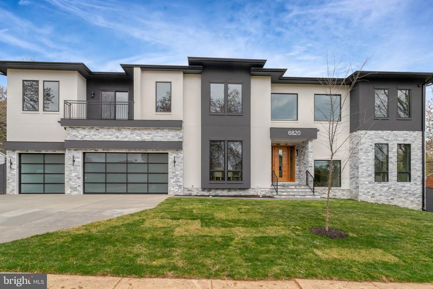 This striking, modern residence offers an expansive 8,453 SqFt of luxury living with a 4-car garage, thoughtfully designed across three meticulously crafted levels. With its bold contemporary architecture, sophisticated finishes, and attention to detail, this home seamlessly blends comfort, style, and functionality.
Upon arrival, you’re welcomed by wide-plank pre-engineered hardwood floors, flanked by sidelights and elegant wall sconces that set the tone for the refined interiors ahead.
The foyer opens into the heart of the home: an open-concept kitchen and family room designed as the central hub for everyday living and grand entertaining. The chef’s kitchen features professional-grade Thermador appliances, including a six-burner gas cooktop, double wall ovens, and a built-in coffee machine. White marble countertops, designer two-tier cabinetry with under-cabinet lighting, and a quartz waterfall island elevate the culinary experience. Brushed-brass pendant lighting provides the perfect finishing touch.
The family room centers around a floor-to-ceiling stone gas fireplace with a custom wooden mantle and built-ins, while French doors open to a covered porch, creating seamless indoor-outdoor living.
For added convenience, a professionally appointed prep kitchen includes an additional gas cooktop and refrigerator, set beside a generous walk-in pantry. Access to the 4-car garage—with one bay deep enough for two vehicles or an RV—is via a well-designed mudroom with built-in storage. A private main-level ensuite bedroom features a custom bathroom with a floor-to-ceiling tiled shower and custom closet system.
A dedicated elevator shaft has been thoughtfully integrated into the home’s design, allowing optional installation of a full residential elevator now or in the future.
Upstairs, a spacious landing with built-in shelving and ambient lighting introduces the private quarters. The luxurious owner’s suite is a true retreat—featuring a separate seating room with coffee bar and gas fireplace, dual private balconies, a tiered ceiling with recessed lighting, a crystal chandelier, and ceiling fan. Dual expansive walk-in closets offer custom built-ins for organization.
The spa-inspired bathroom pampers with marble flooring, dual vanities with smart-controlled heating and aroma diffuser, a freestanding soaking tub, and an oversized shower with multiple shower heads, seamless glass enclosure, bench seating, and steam bath capability. A well-appointed laundry room with cabinetry and a built-in drying rack completes this level. Each secondary bedroom is ensuite, offering walk-in closets and timeless marble finishes.
The lower level delivers exceptional entertainment and wellness features including a recreation room with wet bar and stone fireplace, a state-of-the-art media room with tiered seating, and a fitness room with direct access to a full bathroom and sauna.
Situated in the coveted Lewinsville Heights neighborhood of McLean, the home offers unmatched convenience to major commuter routes, Tysons Metro stations, and world-class shopping and dining at Tysons Corner.
As an optional upgrade, a pool can be added to further enhance the lifestyle and luxury that this exceptional home provides.