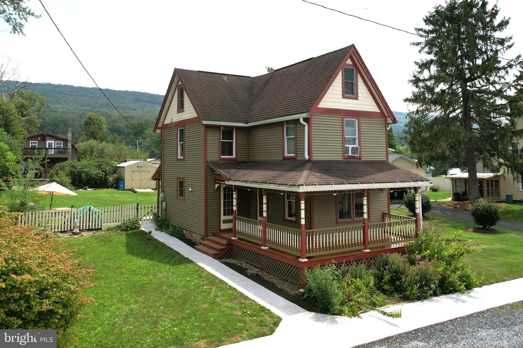 Situated in the heart of Howard, this absolutely adorable two & a half story is overflowing with charm. This meticulously maintained and updated home seamlessly blends classic features with modern conveniences. The exterior presents eye-catching curb appeal with a beautiful wrap-around covered porch.  You will appreciate the attention to detail such as solid wood exterior doors, high ceilings, wide plank hardwood floors, and neutral paint choices.  The main level includes an inviting foyer, spacious living room, and an updated eat-in kitchen with Granite countertops, included appliances, and tile backsplash.  The convenient & recently remodeled half bathroom on the main floor.  The second floor hosts three nicely sized carpeted bedrooms, and recently installed luxury vinyl plank flooring in the hallway. The newly renovated full bathroom showcases a stylish vanity, oversized tile walk-in shower with a glass door, steam shower, overhead rain showerhead, additional handheld showerhead plus a handy fold-up teak shower seat. The finished attic offers flexible space for a home office or guest suite.  Additional amenities comprise mini-split heating and cooling, a pellet stove in the basement for supplemental winter heating, replacement windows, vinyl siding, and a covered rear patio overlooking the lovely flat backyard, shed and additional access by the rear alley. The property is also adorned with berry bushes and Pennsylvania Native Wildflowers planted by the owners. Nearby attractions include West End Park with a boat launch located behind, Howard Elementary School, community playground, ball fields, Foster Joseph Sayers Dam for fishing and boating, Sayers Dam Beach, Bald Eagle State Park, Nature Inn and Russell P. Letterman Campground. Just 21 miles to Penn State University/Beaver Stadium and 16 miles from Lock Haven University, allowing an easy commute in either direction.  The perfect place to call home.