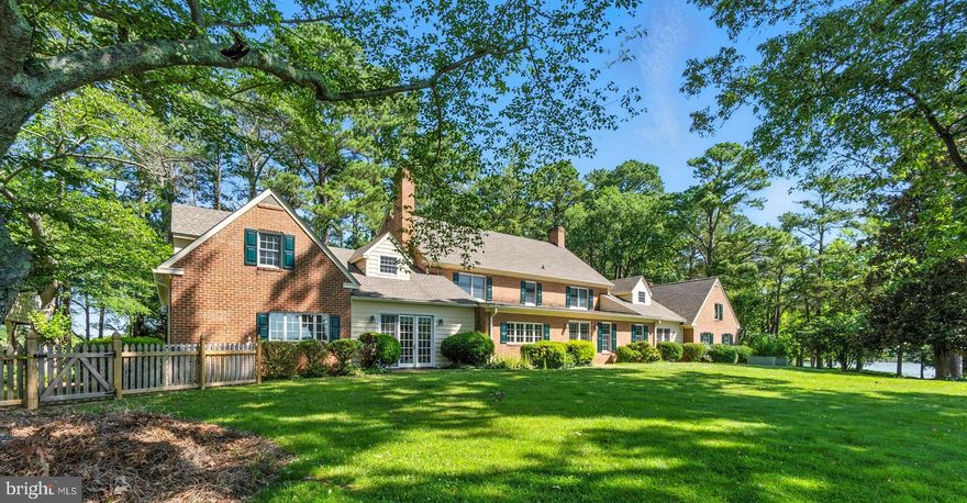 Just minutes from Easton, this stately 9,200 sq. ft. colonial brick home is gracefully sited on 4.8 elevated acres, offering sweeping views of Legates Cove and Peachblossom Creek. Lush landscaping and mature trees create an ideal blend of privacy and expansive waterfront living.

With 6 bedrooms, 6 full baths, and 3 half baths, the home boasts generously scaled rooms, timeless architecture, and exceptional craftsmanship. High ceilings and grand moldings throughout lend an elegant formality, beginning with the impressive foyer and its curved staircase. The formal living and dining rooms are ideal for entertaining, while the great room features vaulted beamed ceilings and an artfully designed gallery with glass shelving to showcase collectibles or fine art. French doors in the sunroom open onto a serene waterside patio, perfect for seamless indoor-outdoor living.

The chef’s kitchen is a standout, complete with two center islands, various prep areas, multiple appliances, a breakfast room, and a spacious butler’s pantry or prep/storage area.

The main-level primary suite serves as a luxurious private retreat, featuring two ensuite baths, his-and-hers walk-in closets, an adjacent office with outside entrance, and a cozy fireplace.

Upstairs, you’ll find four generously sized guest bedrooms, two full hall baths, and access to two attic areas offering abundant storage. A separate in-law suite—with private stairwell off the kitchen—includes a kitchenette, living area, bedroom, and full bath, making it ideal for extended family or guests.

Outdoors, the waterside patio invites relaxed enjoyment of the setting, while the private dock includes a coveted boat house, two additional slips, and 3+/- ' MLW. Whether you’re savoring the broad water views or  the peaceful sounds of nature, this exceptional property offers a rare opportunity to own a classic waterfront estate with space, serenity, and timeless charm.