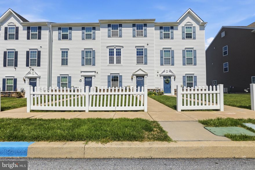 Welcome to 114 N Harner Boulevard, a charming townhome with fantastic potential to make it your own. Enjoy beautiful curb appeal with a well-maintained lawn, classic white picket fence, and a large open common area field just across the street. The entry level offers a flexible sitting area perfect for a den, office, or playroom, plus access to the garage and a mudroom that could double as a workshop. Upstairs, the main living level features hardwood floors, recessed lighting, and an open kitchen and living room. The kitchen includes stainless steel appliances, granite countertops, a double sink, 42-inch soft-close cabinetry, and a custom shiplap accent wall. The primary suite offers a ceiling fan, a walk-in closet with custom built-ins, and an ensuite bath with dual shower heads, custom tile, and crown molding. The top floor is completed by a convenient laundry area and two additional bedrooms with batten paneling and crown molding. The community features a playground, clubhouse, pools, trails, and sidewalks throughout, and is located about an hour from Philadelphia, with easy access to West Chester, local parks, and area amenities. This home offers a prime location and outstanding potential, ready for your personal touch to make it shine.