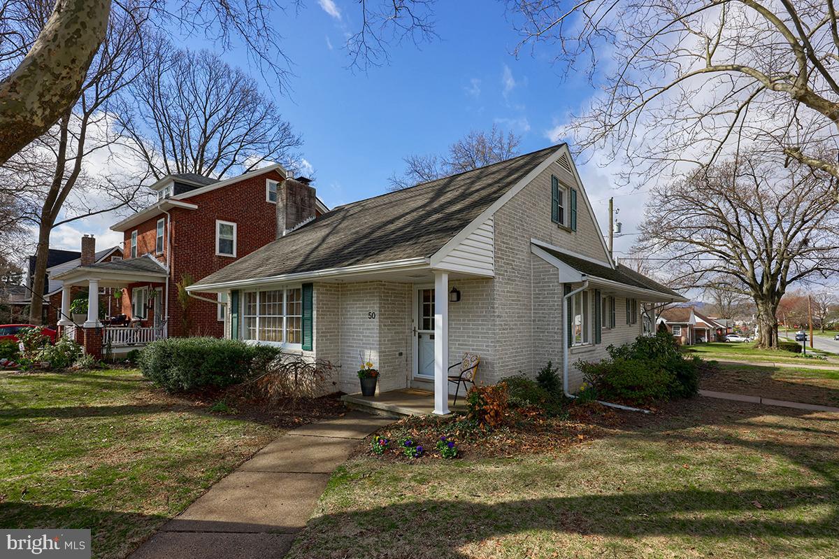 Impeccably maintained, and tastefully updated 4 bedroom, 2.5 bath Single Family Home, located in the West Lawn section of Spring Township, within the ever popular and award-winning Wilson Area School District. This brick and vinyl sided 2 story home, located on the corner of W. Court Boulevard and Belmont Avenue, has a beautiful front yard on two sides, with manicured flower beds, huge shade bearing sycamore trees, and a one car detached garage with a private concrete driveway. The architectural asphalt roof was replaced in 2014 and the home has two covered patios. The main entrance to the home, located on the W. Court Blvd. side, welcomes you into a spacious family room, with beautiful oak hardwood flooring, neutral earth toned decor, and a natural gas fireplace with brick hearth and wood mantle. adjacent to the family room is the formal dining area, that is open to the recently remodeled kitchen. The kitchen has a built-in wooden breakfast bar, with matching shelving above, ceramic tile floors, white cabinetry with matching hard surface counter tops, undermounted farm style sink, ceramic tile back splash, with all stainless-steel appliances remaining. This traditional home has a very open main level floor plan that is perfect for entertaining. The main level of this home features two bedrooms. The primary owner's quarters is spacious and bright, with hard wood flooring, a walk in closet, and its own private full bath with tile shower and tile floor. The second bedroom on the main level is currently being utilized as a study/den but is close enough to the primary suite to serve as a nursery. There is also a convenient half bath on the main level as well with a very unique vessel style sink and sewing machine vanity. The second floor has beautifully finished and stained pine wood flooring throughout the recreation room, with 2 additional bedrooms on the level, all served by a second full bath with shower tub combination. This home has a dry, full, unfinished basement with laundry and HVAC systems located on this level. This home could not be more charming and well cared for, not to mention being only blocks and walking distance from all of the schools, sports fields, playgrounds, community pools, as well as the downtown areas of West Lawn, and the conveniences and restaurants along nearby Penn Avenue. This home truly does have everything you've been looking for in your next home!