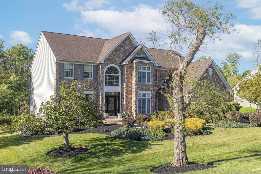Nestled within the tranquil enclave of Newtown Meadows and just moments from Tyler State Park, this distinguished stone front colonial residence offers a seamless blend of timeless elegance, modern comfort, and exceptional outdoor living. Featuring 5 bedrooms, 4 full baths, and 1half bath, the home is thoughtfully designed to balance refined entertaining with everyday functionality. A dramatic two-story foyer creates a grand first impression, welcoming you into a light-filled interior enhanced by rich hardwood flooring throughout the main living areas. The formal living room offers charm and sophistication, while a private study provides the perfect work-from-home setting. A formal dining room is perfectly suited for special occasions, while the family room’s elegant fireplace adds warmth and comfort for everyday living.
At the heart of the home, the gourmet kitchen is beautifully appointed with upgraded countertops, a spacious center island, gas cooktop, double wall ovens, and a generous pantry. The kitchen flows effortlessly into the breakfast area and inviting family room, creating an ideal space for gathering and entertaining. 
Upstairs, the second level features four generously sized bedrooms. The luxurious primary suite serves as a private retreat, complete with vaulted ceilings, a spacious sitting area, two walk-in closets, and a recently renovated  spa-inspired bath featuring a soaking tub, vaulted ceiling  and separate stall shower. The finished lower level expands the home’s versatility with abundant space for a media room, fitness area, playroom, or additional office, along with a bedroom and full bath. There is also a large storage room. Outdoor living is equally impressive. A large deck with retractable awning graces the back of the home that overlooks undeveloped woods that creates the ultimate in privacy. The yard is perfect for recreation or quiet relaxation with plenty of room for a pool. Residents of Newtown Meadows enjoy beautifully maintained common areas and scenic walking and jogging paths, all while being just steps from the trails and natural beauty of Tyler State Park. Conveniently located minutes from the shops, dining, and charm of Newtown, this exceptional property offers a lifestyle defined by elegance, comfort, community, and connection to nature.
