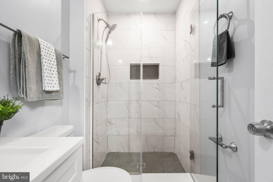 ***ONE YEAR HOME WARRANTY INCLUDED***
This beautiful 3-bedroom home in the desirable neighborhood of Woodlawn is a rare find. The property offers an attached two-car garage (unusual here) and a fully finished basement. 


The home has terrific curb appeal, and landscaped flower beds surround the front porch. Step inside the entry door for a split-level layout with a completely renovated interior. This custom-designed residence includes new luxury vinyl plank flooring, fresh paint in a neutral palette, and large windows that let in lots of natural light. 


The elegant and timeless kitchen anchors the main level and features two-tone Shaker cabinetry, recessed lights, gorgeous quartz countertops, and stainless steel Whirlpool appliances. 


Down the hall, no expense was spared in the two stunning full bathrooms (1 ensuite, one hallway). They have been updated with new vanities,  modern fixtures, and custom tile work that goes to the ceiling. The primary ensuite boasts a frameless glass shower door and a stylish wall niche. 


Are you looking for more storage and additional living space? Head down to the fantastic finished lower level, where you’ll find a powder room and a huge rec room with a cozy fireplace. You can also access the immaculate garage from the lower level. The outdoor space surrounding the highly-esteemed Glenridge Middle School is currently being developed and improved through construction efforts.


Woodlawn is a quiet, walkable neighborhood close to parks (Glenridge, Riverdale) and schools, with all the shopping and dining at Capital Plaza Mall just 6 minutes from your front door. It’s an easy commute to D.C., as you’re only 8 minutes from the New Carrollton Metro station.