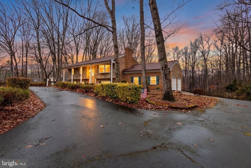 Stunning All-Brick Estate on 2 Private Acres – No HOA!   
Experience the perfect blend of timeless elegance and peaceful country living in this impeccably maintained 4-bedroom, 4.5-bath all-brick estate, ideally situated on a level, private 2-acre lot in a prime Stafford location. From the moment you arrive, the circular driveway and stately brick exterior set the tone for what’s inside. Gleaming hardwood floors and abundant natural light welcome you upstairs. The stunning living room features a charming bay window with built-in bench seating — the perfect place to relax and take in views of your expansive property. French doors open seamlessly into the formal dining room, creating an effortless flow for entertaining. Step out onto the balcony to enjoy your morning coffee or unwind on warm summer evenings while watching wildlife across your private acreage. The spacious kitchen offers generous counter space and ample cabinetry, giving you flexibility for casual dining with a kitchen table or hosting in the formal dining room — the choice is yours. Upstairs, you’ll find three generously sized bedrooms and three full bathrooms, including two bedrooms with private en-suite baths. The third bedroom is served by a full hallway bath, offering both comfort and privacy for family or guests. The finished walk-out basement is a true showstopper, highlighted by a dramatic full-wall brick fireplace hearth that anchors the inviting family room. Whether you’re cozying up by the fire, hosting movie nights, or entertaining friends, this space delivers warmth and versatility. Currently arranged with a bar area, the additional recreation space is perfect for a pool table, home gym, crafting corner, or media room. Double doors lead to the expansive deck — ideal for outdoor lounging and gatherings. The lower level also features a private primary suite retreat with dual closets and a spacious en-suite bath complete with a jetted soaking tub — your personal escape at the end of the day. A large laundry room includes not only a utility sink but also a dedicated dog-washing station — a rare and practical bonus! This is no ordinary 2-car garage. Designed with functionality in mind, it features: A center floor drain for indoor vehicle washing, a convenient half bath, a large ventilation hood system ideal for woodworking or auto projects. Whether you’re a car enthusiast, hobbyist, or simply love a well-equipped workspace, this garage delivers. Step outside to enjoy your beautifully manicured, fenced backyard oasis. Host gatherings on the upper deck or relax on the lower patio while soaking in the privacy of your two acres. Recent updates provide added peace of mind, including new water softener system 2025, Well pump 2025, Chimney sweep & seal, Fireplaces cleaned 2025, Roof & Gutters 2021, Updated basement carpeting. Complete with a side-load 2-car garage and no HOA restrictions, this exceptional property offers the ideal balance of space, privacy, and convenience. Whether you’re seeking multi-generational living, a private guest suite, or simply room to breathe — this home truly has it all.