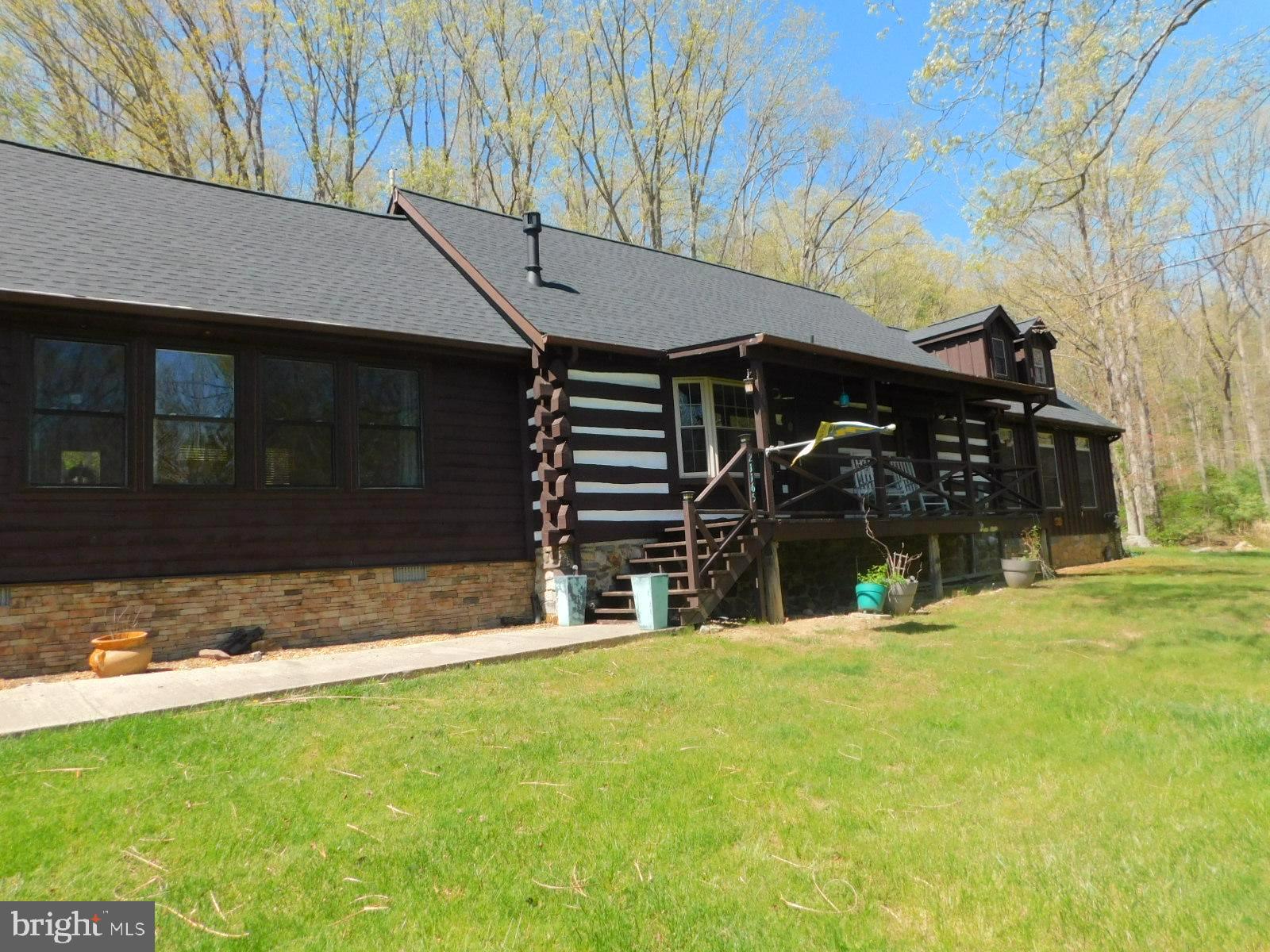 Authentic expanded 3 bedroom , 2 bathroom log cabin with Mountain views and located on a large private lot. The home features one floor living if needed. There is a large stone wood burning fireplace with vaulted ceilings and hardwood floors. There is a beautiful gourmet kitchen with hammered copper sinks and a large granite island and counter-top and fireplace. Dining room is off the kitchen and with views of the front yard. There is a second bedroom and full bathroom off of the kitchen/dining area. Follow the hallway to the laundry room and primary bedroom suite with a walk-in closet and beautiful upgraded bathroom with tile floors, double vanities, soaking tubs and walk-in shower. Upstairs is a nice loft are and a large third bedroom that would be great for the kids! Relax on the screened in porch at the back of the house off of the kitchen. Exterior features are a 3 car garage, fenced area for pets, landscaped garden, waterfalls and Koi pond. Great location just between Wardensville and Baker.