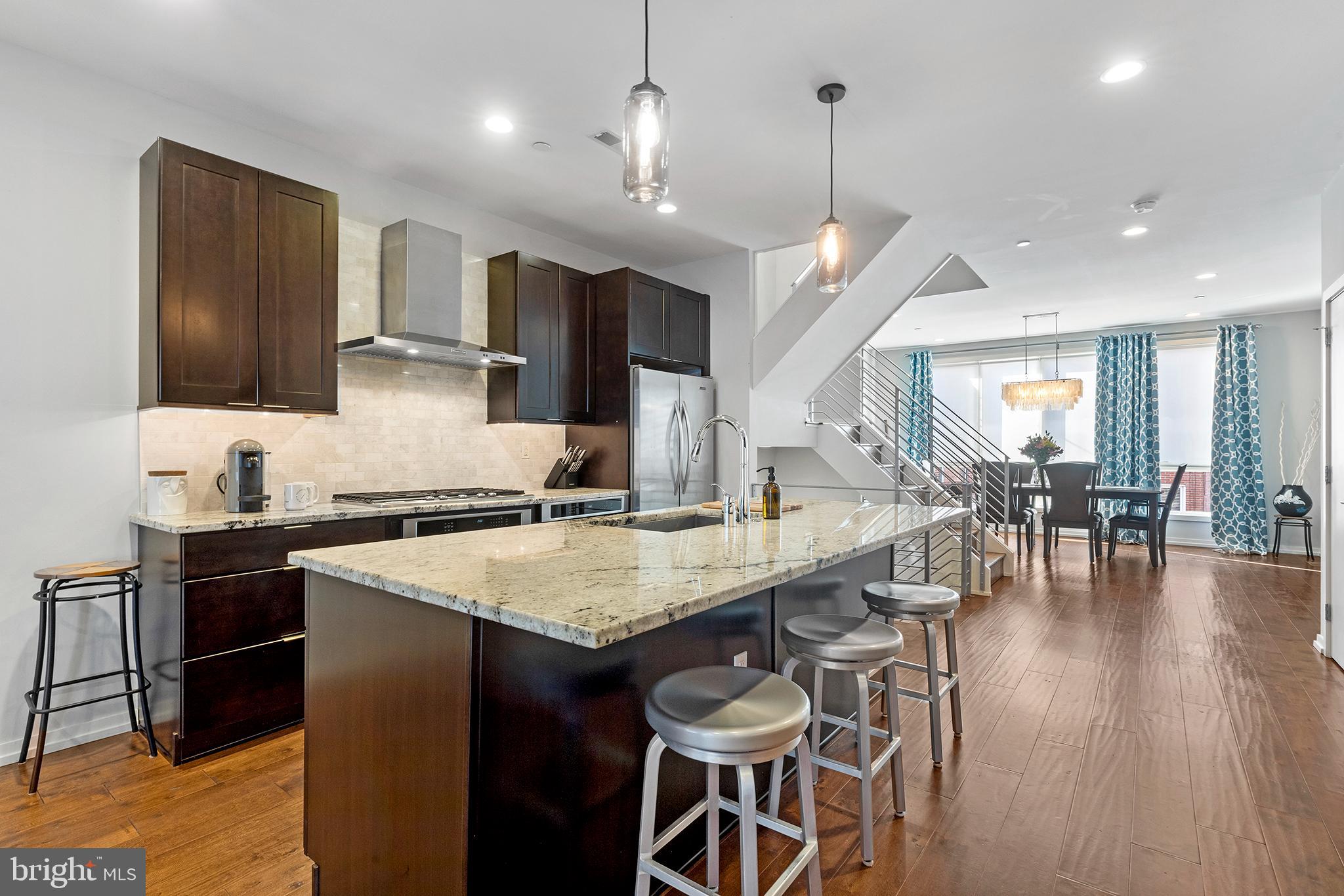 Join us for our grand Open House, Saturday, March 12th 11am-1pm! Welcome home to 927 N Orianna St! This luxurious, modern townhome constructed by reputable local builder Callahan-Ward is located on a quiet, tree-lined street in the heart of Northern Liberties.
 
Immaculately kept, this spacious 3 bedroom, 3.5 bath home features premier 2-car gated parking, two fantastic outdoor spaces - a patio and rooftop perch with beautiful views of the city skyline, as well as upgraded luxury finishes throughout the entire residence. Enter through the front door and into the spacious foyer, which is backed by the architectural staircase and provides your first look of the hand scraped engineered hardwood flooring that can be found on every level of the home. Beyond the entrance the first level also has a half bath, hall closet, and bright bonus room that would make the perfect home gym, office or mud-room with direct double door access to the rear patio and parking area. Head up the staircase to find the open living, dining, and kitchen area. Stretched across the entire second floor of this four floor residence, this level is truly the heartbeat of the home. Flooded by an abundance of natural light, this level centered by the Chef's kitchen, creates the perfect space for gathering with family and friends. Equipped with a Kitchen Aid stainless steel appliance package, 5-burner gas cooktop, built-in microwave, extra large kitchen island with seating for four and Alaskan white onyx tile backsplash the kitchen is sure to impress while incorporating plenty of functionality. The living room provides a lovely space to relax after a long day with a wall of floor to ceiling windows, stunning gas fireplace and custom built-ins. Adjacent to the living room and kitchen is an entire wall of built-in cabinetry with beverage refrigerator and pantry. At the front of the home and open to the kitchen is the dining area with a luxurious chandelier and oversized windows overlooking Orianna Street. Ascend to the third level to find a full bath for guests, spacious secondary bedroom with ample closet space and large windows as well as an upper level laundry room. Down the hall is the spacious and private primary bedroom suite featuring a well-appointed walk-in closet complete with custom built-ins. The stunning attached bath has a double vanity with porcelain under-mount sinks, contemporary lighting fixtures, a luxurious air massage tub and large walk-in shower with tasteful 12x24 tile and waterfall rain head. Last but not least, the top level of this grand home has a third full bath and bedroom as well as an additional and unique indoor/outdoor living/entertainment area complete with a beverage refrigerator mini bar that leads out to the private rooftop patio with incredible views of the city skyline. Stepping out onto the private roof deck it sinks in that this home is everything you could ever dream of: two car gated parking, ample entertaining space and a must-see view of the Philadelphia skyline. Located just steps from Liberty Lands Park, a dog park, and countless restaurants and amenities, this home is truly a walkers paradise. Enjoy brunch at Cafe La Maude, Jerry’s, or Honey's Sit n’ Eat featured on Diners Drive-ins and Dives. Visit Bourbon + Branch, Standard Tap, North Bowl, and El Camino Real for some drinks, food and fun! This home is a must see and we welcome you to come check it out for yourself.