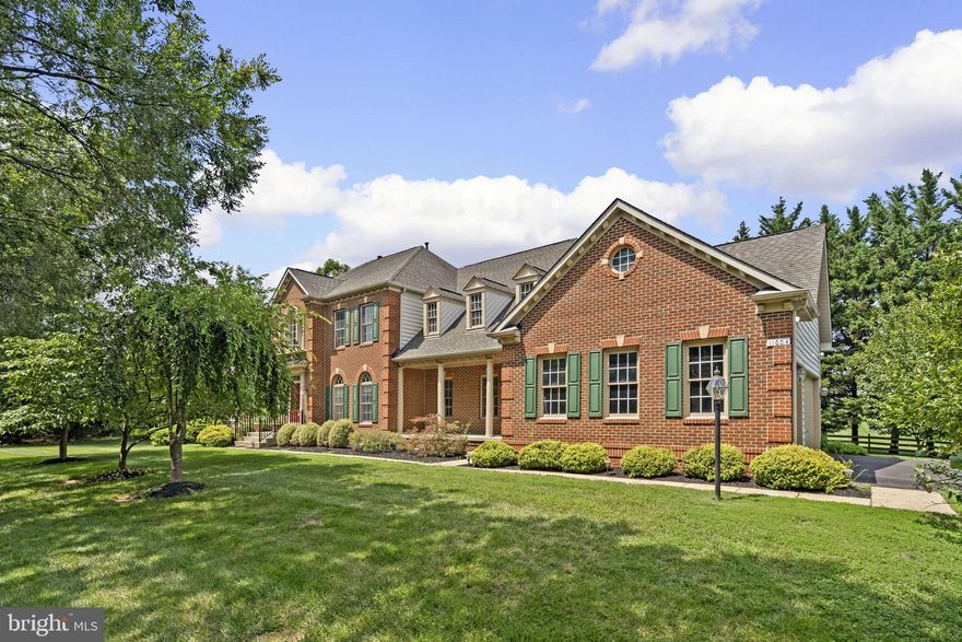 Nestled on a gorgeous lot with lush landscaping, this stately Colonial in the desirable Gaither Hunt community has been lovingly maintained by its original owner and offers timeless elegance throughout. Bright white interiors and a traditional yet open layout create an inviting, airy atmosphere. Soaring ceilings, arched windows, elegant columns, and abundant natural light contribute to a graceful flow throughout the generously sized living areas.

A dramatic two-story foyer with stylish ceramic tile flooring sets the tone. To the left, the formal living room features gleaming hardwood floors and French doors that lead to a sunroom with a tray ceiling and panoramic windows that frame luscious views. To the right, the formal dining room exudes sophistication, adorned with hardwood flooring, a chair rail molding, and a statement chandelier. Straight ahead, French doors open to the expansive family room with hardwood flooring, a gas fireplace, transom windows, and access to the rear deck. A well-appointed main level study with hardwood floors offers flexibility as a guest room with private access to the main level full bathroom. The stunning eat-in kitchen is the heart of the home, featuring a center island with bar seating and modern pendant lighting, stainless steel appliances, ample white cabinetry, and a charming breakfast nook with oversized windows, a writing station, a sparkling chandelier, and deck access. Nearby is a dedicated mudroom that connects to a spacious laundry room.

Upstairs, the luxurious primary suite features plush carpeting and a column-defined sitting room with custom built-ins. The spa-like en suite bath includes a glass-enclosed shower, a corner Roman tub, a dual sink vanity with a makeup station, and a massive walk-in closet. Plush carpeting continues into the three additional bedrooms, each with its own en suite bathroom. Two feature walk-in closets, while the third offers generous double closets. The walk-up lower level includes a partially finished recreation room with decorative columns, a bonus nook, a full bathroom, and a versatile bonus room—ideal for a home gym, guest space, or hobby room. There's also ample unfinished space ready for storage or future customization.

Outdoor living is just as impressive, with a large deck offering sweeping views, a partially fenced backyard, and an expansive side yard lined with mature trees—perfect for relaxing or entertaining in complete privacy.