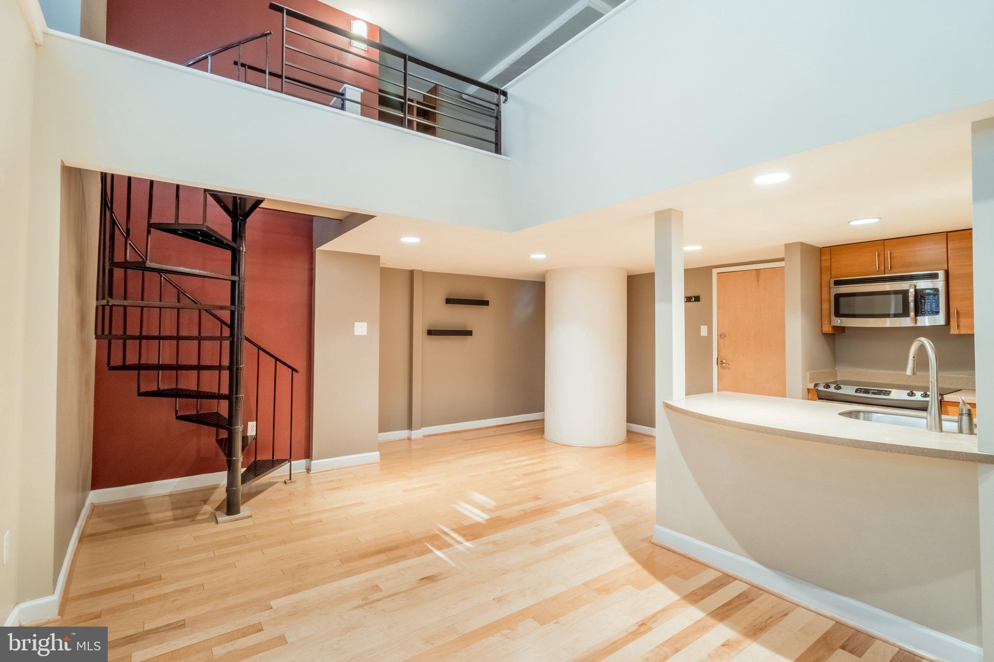 This BI-LEVEL condo *with deeded PARKING*** is located in the Marine Club with 24 hour doorman, large equipped gym, courtyard with fish pond and dog run area. It's a great investment property last garnering $1,500 a month, and is also perfect for a first time buyer. Avoid elevators with this first floor unit! The first floor has an open floor plan with the kitchen separate but open to living room featuring seating at the counter, first floor laundry in separate closet and room for a dining table to your right as you enter. There are built in cabinets on the living room wall and the living space features double high ceilings with large windows that overlook the courtyard pond. Upstairs is the loft style bedroom with custom built open closet featuring drawers, shelving and hanging space. The bathroom has built in nook storage with exposed brick and glass shower/tub door. This unit is being sold with the separately deeded parking spot- accessed via key fob and secure gate. Because of the double high living room ceiling and large windows the space feels light and bright and there is no stress trying to find parking when arriving home! Enjoy the common space in the interior courtyard- multiple seating areas and pond. 3D Virtual Tour: https://my.matterport.com/show/?m=qxg1GtBaaZp&st=2500&lp=1&play=1&qs=1&ts=3&hl=0&brand=0