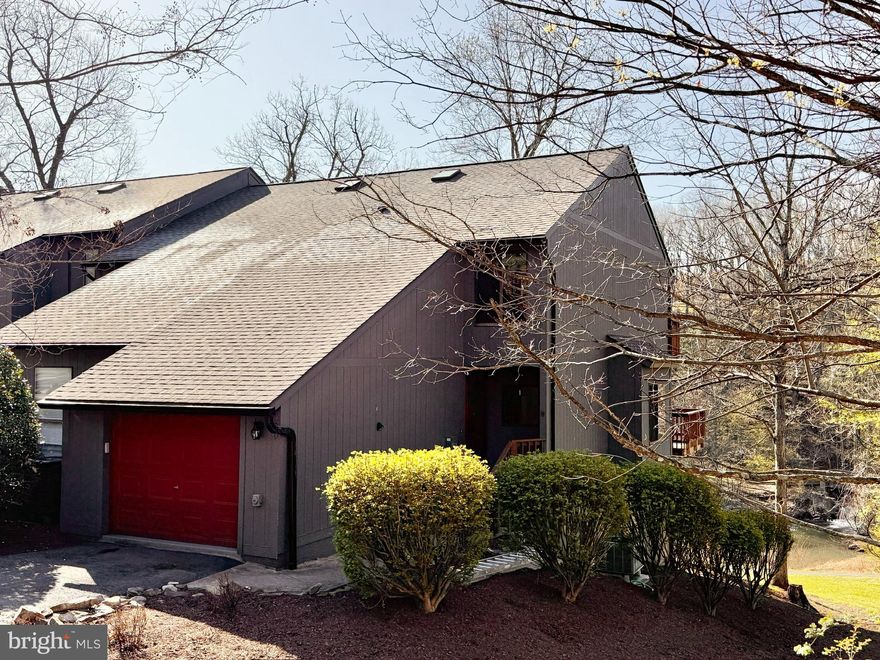 BACK ON MARKET at an improved price!! Check out the video of this "one-of-a-kind," newly-updated and completely refreshed lake-front (with direct waterfall view), three bed/three-and-a-half bath, 2100-square-foot corner unit in the Fishhook Cluster of the Woods. There are three levels of living space, two decks and a patio with a porch swing as well as a one car garage (with a huge storage loft)  with room for two additional cars in the driveway when parked in tandem and a whole-house generator transfer switch (you will bring your own generator.)  The boundary lines were expanded (details in the attached documents ) and the lot on the western side is all woods with nothing to obstruct your view or experience of nature. You can enter the house via the ground level front door, through the garage and also via the ground level backdoor to the lower level suite. Upon entering the front door, one will notice the smashing designer light fixture and the stunning palette on the newly-painted walls. The entire unit was repainted - both inside as well as the decks outside. Completely new modern lighting design throughout the home. There are hardwood floors on the main level; cork in the lower level; and clean, neutral carpet in the upper level bedrooms and closets. The main floor has an open plan, with water views. There's tons of living space with a wood-burning fireplace and sliders opening to the large newly-painted deck with brand new retractable awning. The kitchen lives large - fabulous storage in the upgraded cabinets, including two pull out pantries plus an additional main level storage room for your cleaning supples. The kitchen was just updated with a brand new  Gerber Plumbing Melrose single handle faucet with side spray and soap dispenser, as well as a brand new Samsung oven. The main level has a newly-updated half bath: new toilet, updated vanity, new brushed gold faucet and modern mirror accented by new, designer vanity lighting. Upstairs are two bedroom suites, each with their own ensuite bathrooms and walk-in closets.  There is large efficient laundry center tucked in between the suites at the top of the stairs.  The spacious primary suite (you can definitely put your king-sized bed in there) has water views through the sliding doors out to the deck; high ceilings;  a new modern ceiling fan with light; and TWO walk-in closets, each with closet organization systems and recessed light.  The primary bathroom was updated with a new toilet, new exhaust fan, new faucet, lighting, mirror and vanity and has a large soaking tub and showing with a skylight. Across the hall is the other large bedroom suite with ensuite bath with stall shower and a dressing room with closet system. The bathroom was updated with new faucet, toilet, lighting,  accessories, exhaust fan and updated vanity. The laundry is tucked away in a big closet on the landing between the two bedrooms with tons of light, storage and even a spot for folding and a ceiling fan to keep it cool. The lower level suite has its own private entrance; a modern barn door entry to the bedroom with direct water views (we have it staged as an office).  The suite has it's own living room with built-in bookcases and a newly updated full bathroom with stall shower.  At the base of the stairs is a massive, newly updated and designed pantry. It could easily be renovated into a kitchenette (plumbing is there) This lower level would be the perfect arrangement for an older child,  an in-law or au pair suite; or even a short term rental to help pay the mortgage! The Woods HOA fees include trash and snow removal and the Fishhook Cluster fees include the landscaping and upkeep inside the cluster, as well as a private-to-the-cluster pickleball court and guest parking. The cluster just put on a new roof. HOA/cluster docs, deed, boundary adjustment attached. No fences are allowed by the cluster. Designed and staged by Honey House.