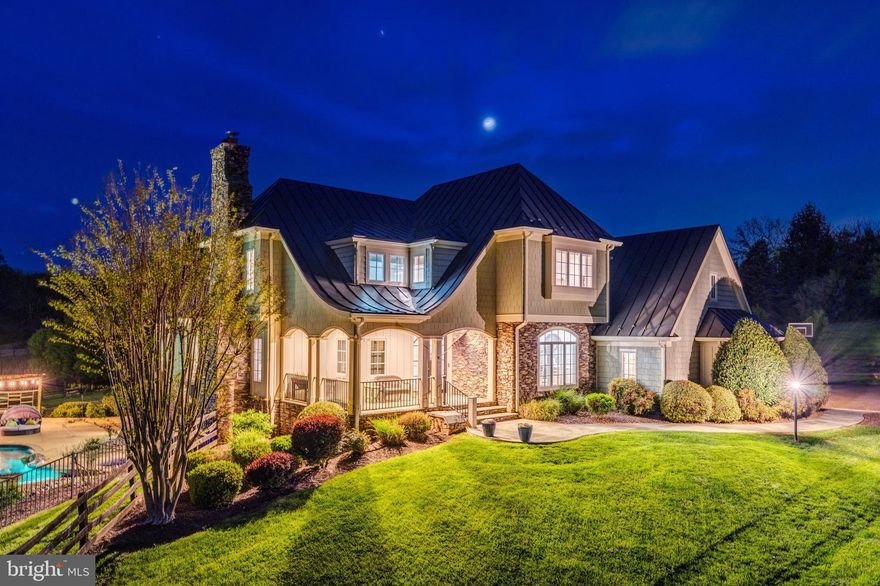 Welcome to Skyfall, a custom-built modern farmhouse thoughtfully designed with the finest materials, exuding sophisticated luxury on 9.08 meticulously fenced acres secured by private electric-gate access. Nestled on prestigious Peale Lane—a secluded enclave celebrated for estate-quality homes amid Loudoun County’s picturesque wine country—Skyfall offers exceptional privacy, yet is mere minutes from vibrant downtown Leesburg. Crafted with impeccable attention to detail, the home's striking entry features imported black French steel doors beneath a dazzling Schonbek German crystal chandelier, accented by tray ceilings and crown molding throughout the main level. Durable Hardi-plank siding, a sleek full metal roof, and new Carrier HVAC systems with UV technology underscore the superior quality of construction. The luxurious main-level primary suite includes dual walk-in closets, French steel doors, and a cozy sitting area with a Jotul wood stove surrounded by marble. Its opulent ensuite bath features reclaimed barn doors, cathedral-arched windows, an oversized Kohler soaking tub, Toto Japanese toilet, dual Indian marble vanities, and frameless rainfall shower. Two chic powder rooms—including one concealed within the laundry—ensure convenience. Ascend the dramatic waterfall staircase to three spacious bedrooms, each with generous walk-in closets. One bedroom has a private ensuite bath with marble vanity; the other two share a Jack-and-Jill bathroom with dual Carrera marble vanities, clawfoot tub, and seamless glass shower. A charming reading nook completes the upper level. The gourmet kitchen impresses with expansive floor-to-ceiling cabinetry, waterfall quartz island with cabinetry on both sides and integrated power, WiFi-enabled Thermador appliances including discreetly integrated fridge, freezer, dishwasher, wine fridge,  6-burner range with griddle, twin ovens and integrated Chef's hood.. Under-cabinet lighting, hidden outlets, and a trough sink with dual faucets enhance functionality. An adjacent hidden pantry mirrors kitchen finishes with quartz counters and open English oak shelves, and handmade hickory barn door entrance. The expansive family room features soaring cathedral ceilings, exposed wood beams, rustic stone fireplace insert, built-in English oak workspace, and access to the wraparound porch. A formal dining room, illuminated by a statement fixture, is perfect for entertaining. The finished lower level is an entertainer’s paradise, highlighted by a reclaimed Virginia barn wood bar with Indian marble, dishwasher, EuroCave wine fridges, beer fridge, and sink. A stacked stone fireplace with Jotul stove warms the rec room, while a hidden theater/music room lies behind a custom bookcase. A guest suite with reclaimed wood vanity and full bath, fitness room, workshop, and ample storage offer additional comfort, all with direct access to the pool deck. The outdoor haven centers around a stunning 30,000-gallon PebbleTech gunite pool, tanning ledge, 8–10-person spa, and impressive 11.5-ft deep end, that slopes to a swallower end.. Exterior amenities include a Trex deck, flagstone patio with Jotul fire pit, and stone-enhanced pool deck. Custom artisan electric gates by Aurora Services on Virginia bluestone columns feature AES PRO smart-device control. Equestrian facilities include a pristine 4-stall barn with new metal roof, hot/cold water, tack room, hayloft, and adjoining 7-acre fenced paddock. Facing nearly due south, Skyfall feels secluded and serene yet is conveniently situated only minutes from Dulles Airport and within easy driving distance of Washington, DC. Located just 4.6 miles from historic Leesburg with quick access to Route 15, the Greenway, over 50 wineries and breweries, and scenic trails including the Appalachian Trail, Skyfall represents a rare opportunity to experience refined craftsmanship and luxurious comfort in Northern Virginia’s most desirable countryside setting.