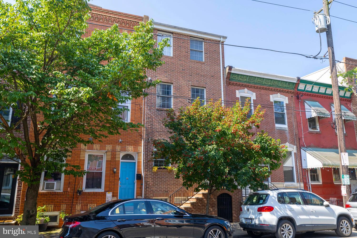 Celebrate the next chapter of life in this South Philadelphia home! Built in 2012 with thoughtful design and solid construction, including wide staircases and hallways, hardwood floors throughout, central air, tankless hot water, and ample closet and storage space, this home is designed for both comfort and functionality. The first floor boasts an open-concept layout ideal for everyday living and easy entertaining, with seamless flow from the living area to the kitchen. The sleek kitchen has stainless steel appliances, metallic tile backsplash, granite countertops, with access to the private patio bordered by a charming brick wall—perfect for outdoor dining or enjoying some quiet relaxation. Upstairs, the spacious rear bedroom features sun-soaked south-facing windows and a large closet, while the cozy front bedroom boasts a one-of-a-kind custom Philadelphia mural. The hall bathroom includes a tub with two linen closets. Up another set of stairs, the expansive third-floor primary suite is a true retreat, complete with an ensuite bathroom featuring a double vanity and a generous walk-in closet. The finished basement, located at garden level, is filled with natural light and features a half bathroom and a large storage closet, making it an ideal flex space for a family room, office, gym, or guest accommodations. The separate utility room includes a washer and dryer (2019), a well-organized 200-amp electrical panel, a new HVAC system (2022), a tankless hot water heater, and updated PVC sewer and water lines. Step out to the Italian Market shops and restaurants, stroll to Capitolo Park, hop on the Broad Street Line, or bike to Center City in minutes—this is quintessential South Philly living. Plus, rare unmetered on-street parking on 10th Street makes life a little easier. A true turnkey opportunity in a highly desirable location, schedule a showing today.