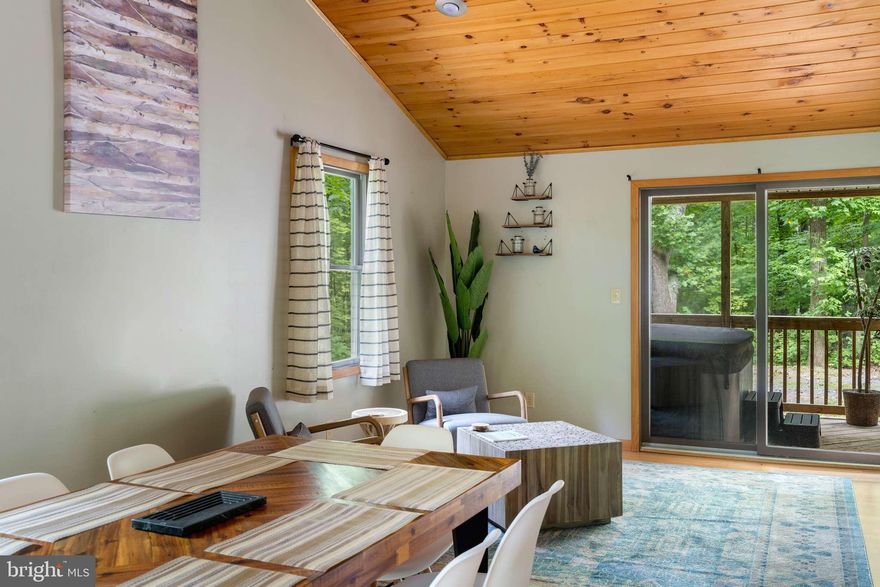 Beautiful, single-level cabin with an open-concept living area and warm wood accents – and just 5 minutes to downtown Berkeley Springs!  Inside you’ll find vaulted wood ceilings, stainless steel appliances in the kitchen, and three generous bedrooms (plus another room that can easily be used as an office or another bedroom) – while outside you’ll find a large covered porch with a hot tub.  As a vacation rental it has generated $121,000 over the past 3 years ($43k over the past year alone), and can come with an existing property manager and cleaner.  Hot tub and furniture optional, available for purchase.  See seller docs for a summary of rental history and financials.  $1,000 buyer credit if you continue using the same property manager.  Perfect vacation home or investment property!