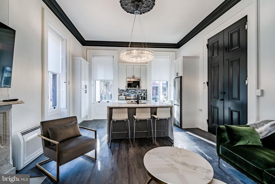 Welcome to 305 S. Walnut Street, a stunning one-bedroom, one-bath luxury apartment that perfectly blends modern elegance with timeless charm. Nestled just steps from the vibrant downtown, this meticulously designed residence offers an elevated lifestyle with every upscale amenity you desire. Step inside to discover soaring 12-foot ceilings, all original woodwork, and exquisite plaster medallions—a nod to the home’s historic roots, beautifully contrasted with sleek, contemporary finishes. The open-concept living space features a waterfall quartz countertop, crystal chandeliers, and remote-controlled blinds for effortless ambiance control. The custom-designed bathroom,  in-unit laundry, off-street parking, and blackout curtains in the bedroom provide convenience and comfort. Unique architectural features like pocket doors add functionality and style, and the enclosed porch makes an ideal home office or reading retreat. From the luxury finishes to the thoughtfully preserved historical details, every inch of this apartment reflects quality and sophistication. Don't miss this rare opportunity to live in one of West Chester’s most sought-after locations.