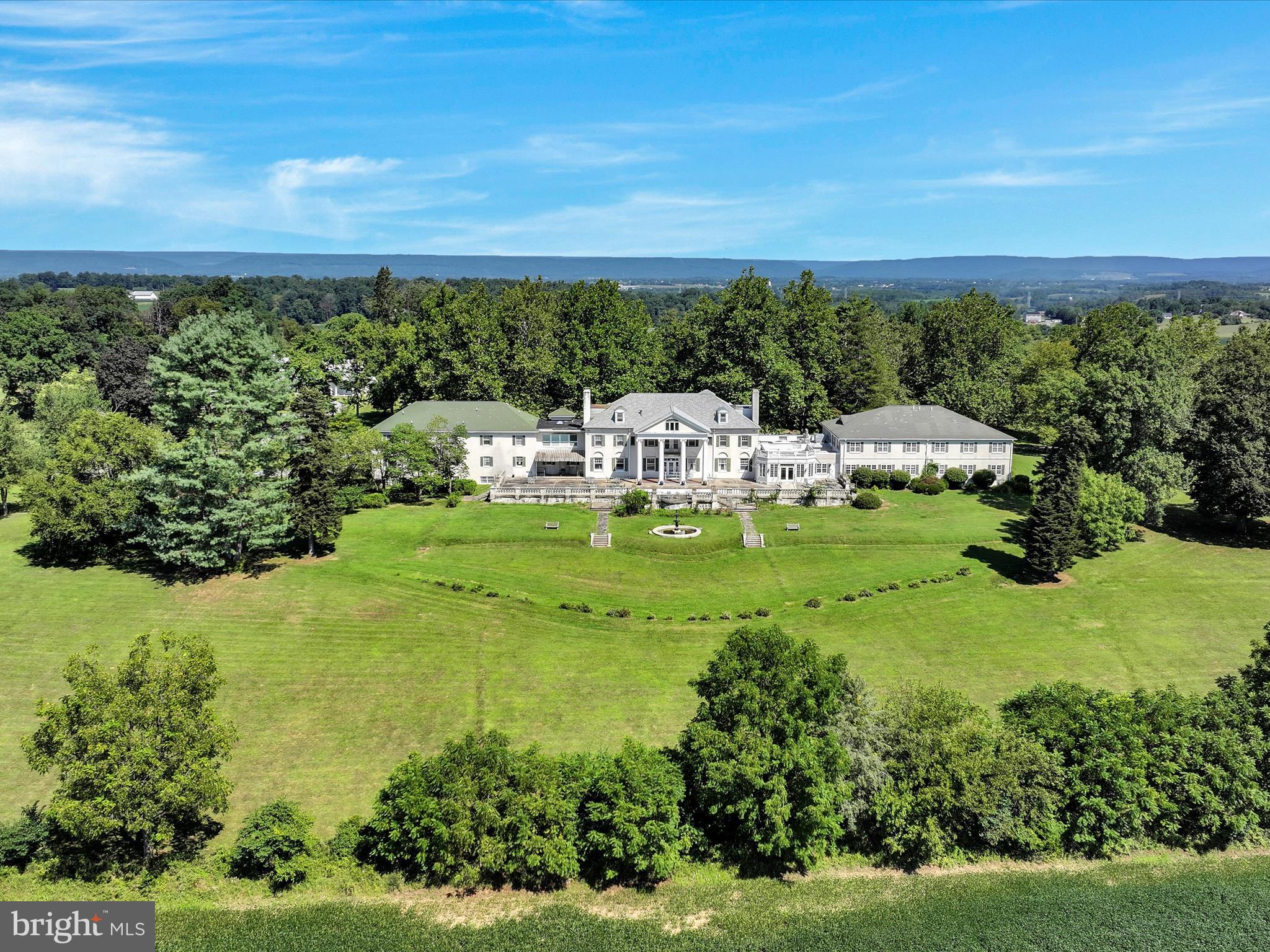Welcome to HILL FARM ESTATE and discover the potential this historically significant 23.8-acre property has to offer! Once the private residence of U.S. Congressman and industrialist Aaron S. Kreider, this Federal-style mansion was later converted into a personal care home operating with 43 private rooms between the main & upper level, multiple common area/gatherings rooms, dining rooms, a commercial kitchen, administrative offices, a huge finished basement and even more space in the finished attic.
The grand terrace is offering sweeping views of the scenic grounds, stretching all the way to Mount Gretna. A separate carriage house adds 7 residential units (three 2-BR and four 1-BR apartments) with 2 units currently being tenant occupied, offering immediate income opportunities. Set in a serene, park-like environment with mature trees and open green space, the property offers a rare combination of historic character and functional capacity. With existing infrastructure already in place, the estate presents a compelling opportunity for continued use as a care facility, conversion into a hospitality venue, wellness retreat, residential community, or adaptive reuse development, all subject to zoning and approvals.
Whether you're an investor seeking steady income, a developer exploring a unique project, or a visionary ready to write the next chapter for this storied property, Hill Farm Estate invites endless possibilities!