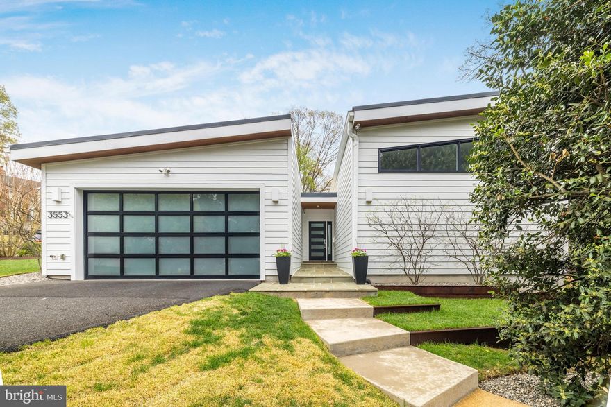 Stunning Modern Classic in North Arlington!

Welcome to 3553 Nelly Custis Drive—where timeless elegance seamlessly blends with modern design. This thoughtfully expanded and renovated home is a stunning condo alternative, offering the ease of one-level living in a warm, inviting space accented by sophisticated, contemporary finishes that strike the perfect balance of style and comfort.

Exceptional Design & Thoughtful Additions include:

A two car garage with a frosted glass garage door, complementing the modern yet timeless exterior
A lighted front entry corridor leading to a grand foyer with soaring ceilings and a statement chandelier
A studio space for a home gym or office
Fenced and fully landscaped yard with sprinkler system
The spa-like primary suite is designed for relaxation, featuring:

Vaulted ceiling with custom windows for natural light
Spacious walk-through closet with custom cabinetry
A gorgeous en-suite bathroom with a large skylight, walk-in shower, and double vanity
Heart of the Home – The Kitchen & Living Area

The renovated kitchen is both practical and stylish, flowing seamlessly into the sun-filled family room. A contemporary Carrara marble slab fireplace, flanked by built-in cabinetry, serves as the centerpiece of the home.

Striking Exterior & Outdoor Features

The home’s exterior is a perfect balance of modern and classic elements, including:

White Hardi siding and brick
Exterior with cedar soffits and black windows
Metal standing seam roof for durability and style
Natural stone entrance pathway with warm, surface-mounted lighting
Natural stone patios in a cedar fenced back yard
Recent Updates & Additional Features

Detached Studio/Home Office/Gym (2021)
New HVAC & Nest Thermostat (2024)
New Built-in Liebherr Refrigerator (2023)
Ipe hardwood deck with planters (2018)
4 Bedrooms | 3.5 Bathrooms | One-Level Living + 2 Car Garage
Nest exterior security camera system
Automatic, programmable sprinkler system
Iconic features include Nelson Bubble Pendant, Eames Hang-it all hooks and Moooi Random Light Pendant
Located in the heart of North Arlington's Crystal Spring Knolls and nestled between the Woodmont, Maywood, and Lee Heights neighborhoods in North Arlington, Crystal Spring Knolls offers a serene yet highly convenient setting. Enjoy nearby Windy Run Park, featuring a scenic trail leading to the Potomac River, while also being within walking distance of shops and restaurants in Cherrydale, Lee Heights, and Spout Run Shopping Centers.

With quick access to D.C. (just two traffic lights away!), the GW Parkway, Route 66, the Custis Bike Trail, and a Metro bus stop, commuting and exploring the area couldn’t be easier. This location perfectly balances nature, convenience, and accessibility.