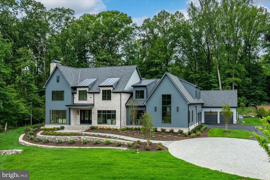 Quiet luxury has a new address in Great Falls. At 796 Falls Farm Court, Brush Arbor Homes has composed something rare - a New American Farmhouse of exceptional confidence and presence, sited up on 1.8 private acres with the kind of intentionality that finds its place in the landscape rather than imposed upon it.

The façade announces its intention immediately: a refined palette of antiqued brick and board-and-batten siding in deep slate grey, anchored by a charcoal standing-seam roof and oversized black-framed windows that draw the eye and invite the light. Tiered stone retaining walls, manicured boxwood plantings, and a sweeping drive compose an arrival that is understated and impeccable. 

11,800+- square feet of thoughtfully designed and light-filled interior space unfolds across three levels with 6 bedrooms, 8 full and 2 half bathrooms and optional elevator — formal entertaining spaces, intimate family quarters, and serene bedroom retreats — creating a warmth and livability that genuinely defies its scale. Wide-plank European white oak floors, soaring ceilings, and walls of glass anchor every room and announce the home's devotion to detail from the very first step inside.

The rear of the home is nothing short of a private resort. A sparkling pool and separate raised stone-bordered spa anchor a generous bluestone patio, while an expansive covered outdoor living pavilion framed in the home's signature board-and-batten and finished with a full outdoor kitchen extends the interior's warmth and sophistication into the open air. A second-level balcony with black metal railings overlooks the entire scene. The surrounding lawn stretches generously in every direction, lush and level, offering abundant space for recreation, entertaining, or simply breathing room.

This home's magic is found in the minutiae-in the deliberate choices that distinguish the exceptional from the merely impressive. Bespoke millwork and wainscoting, designer fixtures, and furniture-grade cabinetry and built-ins reveal a level of craftsmanship that must be experienced firsthand. Each room carries its own character while flowing effortlessly into the next, a testament to architecture that is as intelligent as it is beautiful.

796 Falls Farm Court is a showcase of the best of everything the market has come to expect from Brush Arbor Homes. The discerning buyer will simply need to see it for themselves. Schedule a tour, and discover that true luxury is not simply seen, but deeply felt.
