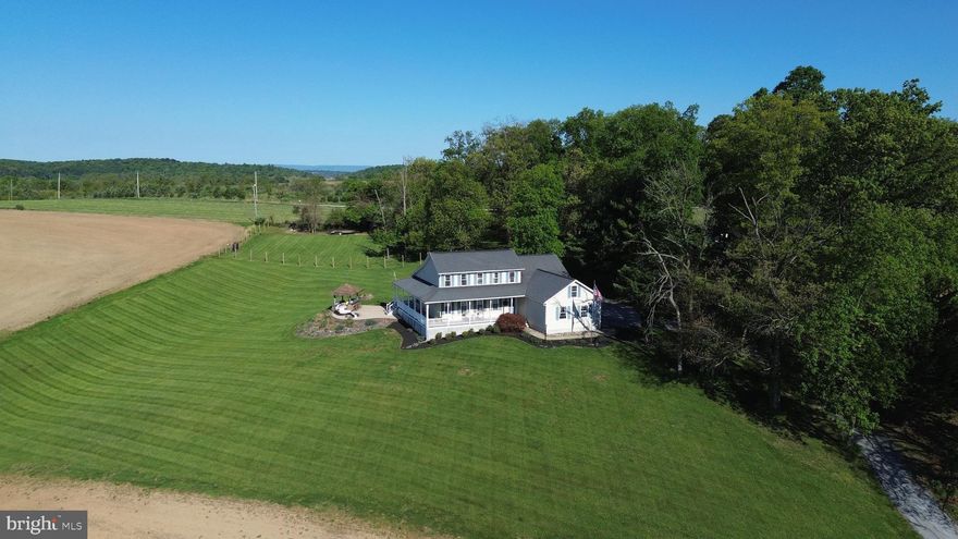 Welcome Home to This custom built Colonial on nearly 2 beautiful acres here in New Windsor, MD. The home is very charming with a unique layout and original hardwood flooring, while the setting is private and the views from the wrap around porch and patio are unmatched! The main level features a primary bedroom, full bath w/ custom shower, and walkin closet.. vaulted ceilings in the great room, skylights, a brick fireplace, granite countertops in the kitchen, formal living/dining room or private office space! The upper level features 3 additional bedrooms with connecting full bathroom. The lower level offers another 770sq ft of finished living space including an exercise room, new LVP flooring, game room, wood stove, and plenty of storage. Step out back and enjoy the scenery from the large patio with a cool drink at the Tiki Bar.. PERFECT for entertaining!.  Notable updates include a recently replaced HVAC, kitchen appliances 2024.  Centrally located between Westminster, Mount Airy, Frederick, and Eldersburg.  Book your showing today!