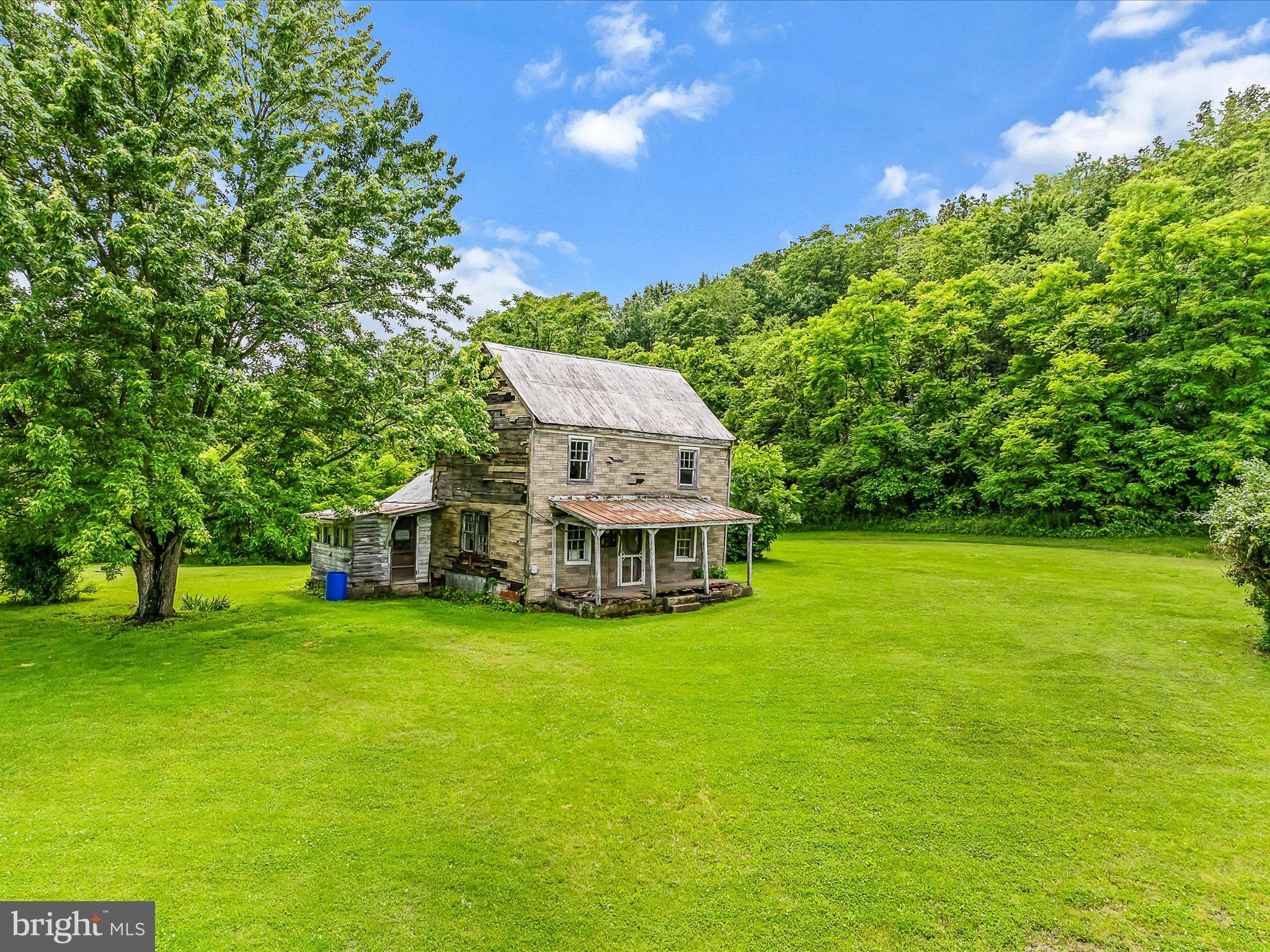 GREAT LOCATION don't miss this 3.22- acre lot sitting on WV Rt 9 in eastern Morgan County. Majority of this lot is level making it great for building your home. This property is just 1 mile west of the Morgan/Berkeley County line on WV Rt 9 making it easy access to Martinsburg, Falling Waters and I-81. Property has the original home, but it is not safe to enter. Well & septic are in place. The possibilities are endless for this lot, so don't hesitate to take a look.
OWNERS STRICTLY STATES, "NO ONE ENTER HOME, PORCH or CELLAR". Park at realtor sign. Do not drive in yard. Building at rear of property is not part of property.