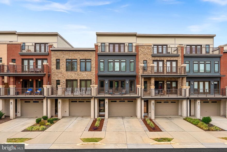 Welcome to this stunning contemporary townhome in sought-after Ashburn Overlook, where modern style, comfort, and convenience converge. This beautifully upgraded 2018 home blends sophisticated design with peaceful living—located just steps from the W&OD Trail and just minutes from Belmont Station, Trailside, and Stone Bridge schools. Meticulously maintained, it features an open-concept layout with hardwood floors, a cozy gas fireplace, and premium builder/custom upgrades. In 2025, the interior was professionally repainted  for a fresh, move-in ready feel. The main level offers a gourmet kitchen, quartz waterfall style island, and double ovens—perfect for cooking and entertaining. Light-filled living and dining areas open to a front balcony. Upstairs: a luxurious primary suite with tray ceiling, walk-in closet, and spa-like bath, plus two bedrooms, upgraded full bath, and large laundry room. The spacious loft level offers a multitude of possibilities - planty of space for a media room, office, home gym, or play room. The loft is complete with a half bath and second large balcony. The lower level includes a spacious recreation room, with a door directly to the serene backyard complete with a paver patio. Additional features include a fully finished garage with  polyaspartic-coated flooring, custom storage, and thoughtful finishes throughout. Enjoy modern elegance, privacy, and a vibrant, amenity-rich community—this home truly has it all.