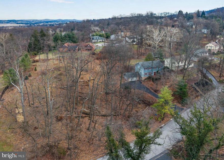 Tucked away in the trees within the established Timber Ridge neighborhood of New Cumberland, this private retreat offers a rare opportunity to own over an acre of land in an exceptional location. Two lots are included, providing space, privacy, and flexibility that are increasingly hard to find. While the home is ready for modern day cosmetic updates, many of the major investments have already been completed, including a newer roof (2015), HVAC system (2022), and a recently resealed driveway with ample parking for multiple vehicles, a boat, or camper. A generously sized garage adds even more functionality. Offering over 2,500 square feet of living space, the home welcomes you with a formal foyer showcasing original trim details along the staircase. The main level features a spacious living room, designated dining area, and a well-sized kitchen with an eat-in space. A cozy family room with a wood-burning fireplace and exposed beams adds warmth and character. Upstairs you’ll find four generously sized bedrooms, including a primary suite with the space and layout to create the primary bath and closet of your dreams. A large second-floor laundry room and full guest bath, both ready to be reimagined, add to the home’s strong bones. Out back, a large, flat grassy yard offers the perfect spot for play, entertaining, or simply enjoying the peaceful, wooded surroundings and local wildlife. Located in the West Shore School District (Cedar Cliff High School), this home boasts easy access to I-83, the PA Turnpike, grocery stores, and everyday amenities, with convenient commutes to Harrisburg, York, and Carlisle. Opportunities like this - over an acre, total privacy, and a prime location at this price point, are truly rare. This home is ready for someone with vision to make it their own.