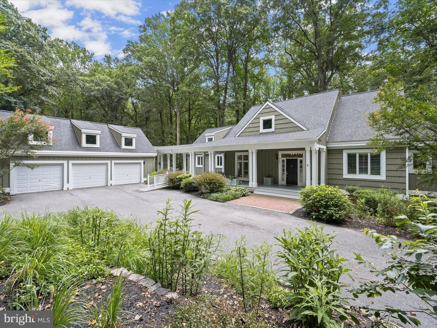 Completely secluded, this stunning residence offers the ultimate private retreat. A brand-new roof installed in 2024 ensures peace of mind, while exceptional main-level living is complemented by a beautifully finished walkout lower level and an expansive three-car garage with gleaming epoxy floors and a walk-up upper level for added flexibility.  Arrive at an impressive covered front porch featuring a shiplap teak ceiling that sets the tone for the refined interiors. Step inside to discover an open floor plan with rich hardwood flooring and a soaring vaulted ceiling with skylights that floods the living and dining areas with natural light. The updated kitchen showcases refinished cabinetry, granite countertops, new stainless steel appliances, new light fixtures, and stylish trim details. Ceiling fans throughout enhance comfort and airflow.  The spacious primary suite, conveniently located on the main level, offers custom built-in storage, an enormous walk-in closet, a newly installed shower door, and a spa-inspired bath with a jetted tub, separate shower, and granite-topped vanity. Wood flooring extends into the main-floor bedrooms for added warmth and charm. A dedicated home office features custom built-in bookcases and a wood-burning fireplace for a welcoming, classic atmosphere. Additional main-level highlights include a mudroom with a secondary entrance, a well-equipped laundry area, and a dual-entry bath connecting to a second bedroom for optimal privacy.  Designed for entertaining, the lower level boasts a remarkable family room with 100-year-old rustic barn flooring, a wood-burning stove framed by a dramatic stacked-stone accent wall, and a stylish wet bar, perfect for gatherings. Two atrium doors open to the lush backyard, creating seamless indoor-outdoor living. This level also features two spacious bedrooms with walk-in closets, new wood flooring, and a fully remodeled full bathroom with an oversized frameless glass shower, quartz vanity, and charming beadboard accents. An added exercise room expands the home’s versatility, while new stairs and thoughtfully upgraded finishes throughout provide a polished feel.  Other significant upgrades include the entire interior repainted, composite siding replacing trim boards for durability and low maintenance, and attention to detail throughout that truly elevates the home's appeal.  Experience refined living in a tranquil setting, luxury, comfort, and privacy come together in perfect harmony.