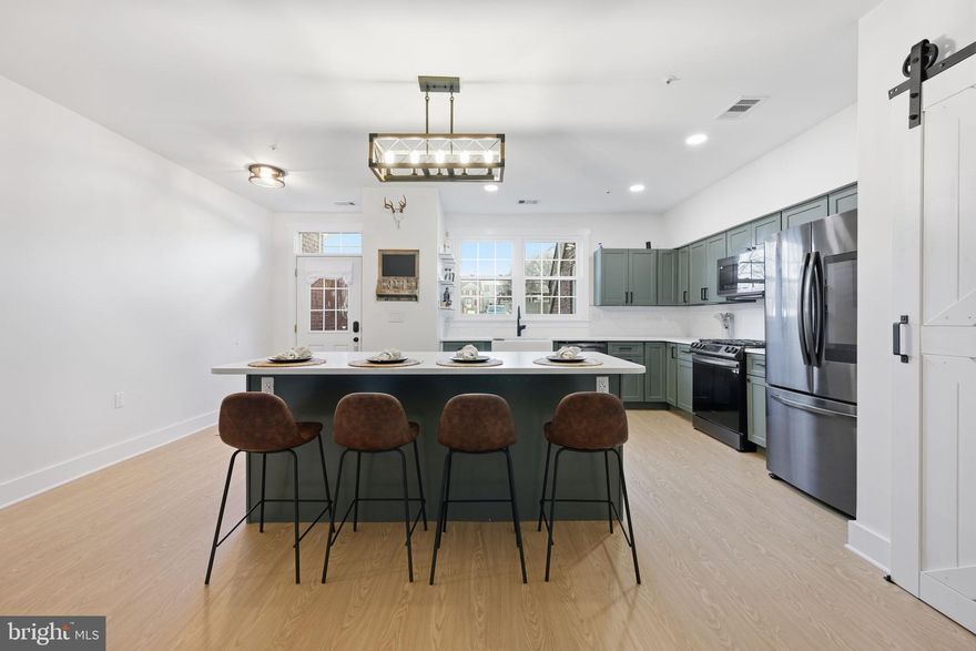 This fully renovated, bright ground floor residence offers modern style and exceptional comfort. Luxury plank vinyl flooring runs throughout, creating a seamless, stylish look. Step into a stunning new kitchen featuring quartz countertops, smart appliances, updated lighting, shiplap accents, and stylish barn doors. The spacious bathroom has been completely redesigned with a tub/shower combination, a separate walk-in shower, and luxurious heated floors. Enjoy a fully fenced backyard, perfect for outdoor dining, relaxing, or pets. New windows, HVAC, washer/dryer were part of the recent upgrades. Storage lockers in the front and rear of the home. Located in the desirable Stonehaven Mews community, residents enjoy access to a outdoor pool and open common green spaces. Perfectly positioned across the street from Waugh Chapel Shopping, you’ll have dining, boutiques, groceries, and entertainment right at your doorstep. Move-in ready and beautifully finished, this home truly has it all.