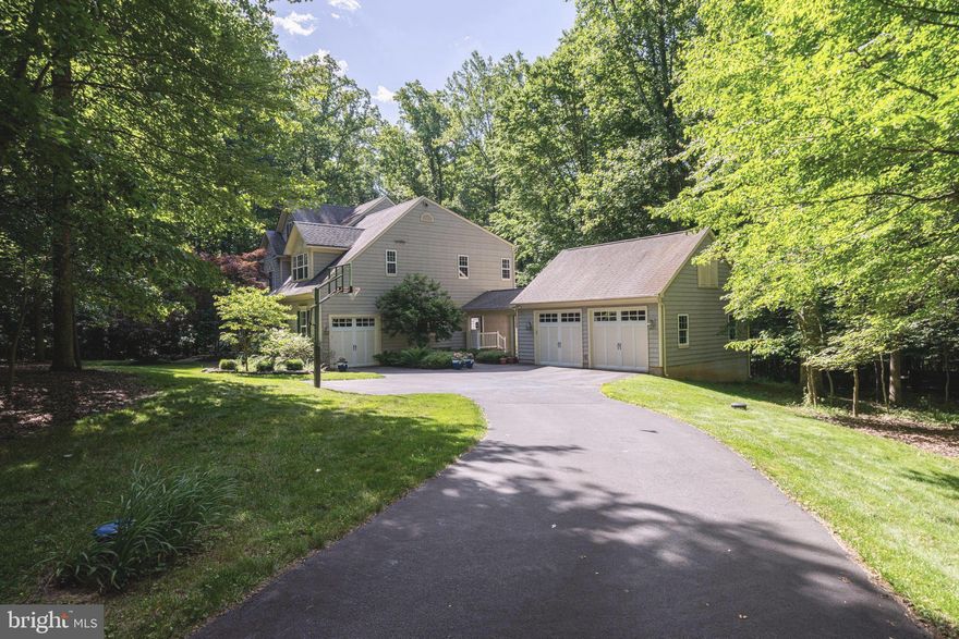 OPEN HOUSE WEDNESDAY APRIL 29TH FROM 5-7PM. OPEN HOUSE SUNDAY MAY 3RD FROM 2-4PM.
ALL OFFERS WILL BE PRESENTED UPON RECEIPT. 
Welcome to this exceptional residence, gracefully set on 3.85 acres and embraced by a serene backdrop of mature trees, offering a peaceful retreat immersed in nature’s beauty throughout every season. A charming, covered front porch invites quiet mornings with coffee and tranquil views of the surrounding landscape, setting the tone for the refined elegance found within.
Upon entry, a dramatic two-story foyer unfolds, adorned with a new chandelier, intricate millwork, and a striking oak staircase that overlooks the soaring two-story great room. The formal dining room is both elegant and inviting, enhanced by detailed trim work, a new drum shade chandelier, and expansive windows that bathe the space in natural light. Opposite, the living room echoes this sense of refinement, with generous proportions and picturesque views of the natural setting beyond.
Tucked privately off the rear hall, the home office is a sanctuary of productivity, featuring custom built-ins and a sunlit bay window that frames the peaceful rear grounds. Nearby, a thoughtfully placed powder room adds convenience.
At the heart of the home, the great room captivates with its soaring ceilings, dramatic stone fireplace, and walls of windows that blur the line between indoors and out. The space flows effortlessly into the casual dining area and the beautifully renovated kitchen, creating an ideal setting for both intimate gatherings and grand entertaining. The kitchen is a study in timeless design, featuring crisp white shaker cabinetry, leathered granite countertops, stainless steel appliances, and natural slate flooring that carries through to the family entry and laundry spaces. Thoughtful details abound, including a charming coffee bar and well-planned storage solutions.
A covered breezeway connects the garage to an expansive family entry, complete with built-in cubbies and concealed storage, leading seamlessly into a spacious laundry room and additional flexible workspace. From the casual dining area, step out onto the expansive deck—an inviting outdoor haven for dining al fresco, entertaining, or simply enjoying the surrounding mature landscape in peaceful solitude.
An additional rear staircase leads to the upper level, where the primary suite offers a private retreat with a sitting area, dual walk-in closets, and a spa-inspired bath featuring a soaking tub, walk-in shower, dual vanities, and private water closet. Three additional bedrooms provide comfortable accommodations, including one en-suite and two sharing a well-appointed hall bath.
The walk-out lower level extends the home’s living space with remarkable versatility, offering a large recreation room filled with natural light, a stylish wet bar with seating, a guest den, built-ins for storage, and a cedar closet. A full bath, cedar closet and ample storage complete this level, with direct access to the rear lawn and natural surroundings.
Additional features include both an attached garage and a detached two-car garage connected by the covered breezeway, enhancing both function and charm.
Outdoors, the grounds have been thoughtfully curated with lush perennials and flowering shrubs, creating a tapestry of color that evolves beautifully from spring through fall. This is more than a home—it is a private sanctuary where refined living and natural beauty exist in perfect harmony.
Located just minutes from Brambleton, parks, wineries, Dulles Airport, top rated schools and more, this property offers a peaceful existence with nature, and  just a few minutes away from the necessities of daily living, the perfect balance.