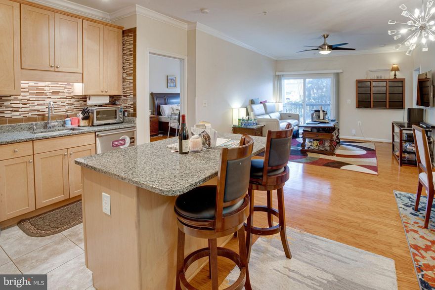 Live in luxury with every convenience at your fingertips!  You'll immediately notice the high end finishes throughout in the kitchen and baths, including granite counters, SS appliances, and custom tile work. High ceilings, crown moldings, gleaming hardwood floors, full size Washer and Dryer in unit, and spacious balcony that can be accessed from the Living Room or the bedroom, ceiling fans, and custom shades.   Perfect floor plan with 2 spacious Bedrooms on each end of the apartment unit, with the Living Room, Kitchen, and Laundry Room in the center.  Each Bedroom has its own Ensuite Bathroom.  Photos are from when the home was fully furnished.  The home will be rented as partially furnished with Sofa and Dining Set.  Fairfax Ridge is a gated community with amazing amenities including outdoor pool, clubhouse, business center, game room, grill area, walk/jog path, and fitness center.  Great location close to Rt 50, I-66, 29 Fair Oaks Mall, Fairfax Corner, Fairfax Government Center, Wegman's, Whole Foods, Costco, and many more amazing restaurants and shops.  Assigned parking space #130 and plenty of street parking right outside the unit.