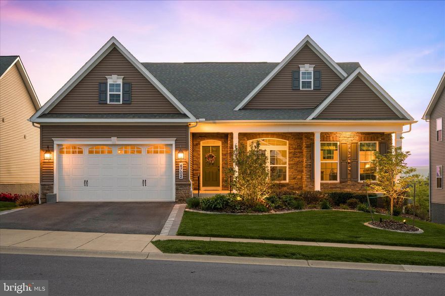Welcome to 4702 Joe Foss Way—an elegant and fully upgraded Carolina Place model in Woodbourne Manor, Jefferson, MD. This spacious home offers four bedrooms with a designated office: two on the main level, one in the bonus area on the second floor, and a walkout-level bedroom downstairs. The main level features tall ceilings with custom trim work and a convenient main-floor laundry.

The upgraded kitchen showcases quartz countertops with a large center island, a tile backsplash, a walk-in pantry, a gas cooktop, and stainless steel appliances, along with a bump-out morning room—making entertaining a dream. The morning room also opens to the covered rear porch, providing a second access point to the outdoor living space. Throughout the main level, enjoy beautiful hardwood floors, a wood staircase, designer lighting, and loads of natural light. The spacious owner’s suite with tray ceiling, large walk-in closet, and en-suite also offers private access onto the covered rear porch.

The finished walkout basement includes a rec room, full bath, bedroom, wet bar, media room, and ample storage space, with double patio doors leading directly to a professionally designed paver patio featuring a built-in gas firepit, Trex pergola with retractable canopy, and future-ready conduit for expansion. Beneath the rear covered porch is a cozy, tucked-away outdoor retreat—creating an additional outdoor “room” for relaxing or entertaining.

The property’s upgraded landscaping completes the outdoor experience, with professionally designed and planted beds, a covered front porch, and beautiful curb appeal that welcomes you home. The expansive patio area is where this home truly shines—featuring both fire and water elements that are beautifully balanced, creating an incredibly relaxing setting.

What the sellers love most about this home is the incredible outdoor space—where natural elements come together to create a peaceful, inviting atmosphere. Whether dining under the pergola or enjoying a quiet drink on the patio, it’s a space they’ve truly loved and one that makes everyday living feel special.

Backing to open green space with a walking path, you’ll enjoy a sense of privacy while still being connected. Located just minutes from Frederick, commuter routes including Route 340, and surrounded by nature trails and parks, this home offers the perfect blend of luxury, comfort, and lifestyle.