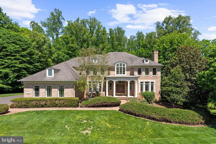 This distinguished brick colonial estate residence is ideally situated on 1.73 private, landscaped acres backing to mature trees — a rare find tucked along a quiet cul-de-sac off River Bend Road in the heart of Great Falls.
The home has been meticulously maintained and thoughtfully upgraded throughout, with hardwood floors, custom millwork, crown molding, recessed lighting, and four fireplaces lending warmth and refinement to every room. The layout flows beautifully — a formal dining room and front sitting room for gracious entertaining lead to a sun-drenched two-story living room for everyday living. The eat-in kitchen opens to a charming sunroom, an ideal setting for leisurely mornings or intimate meals. A private study with built-ins and French doors, two powder rooms, and a well-appointed mudroom with laundry complete the main level.
Upstairs, four generous bedrooms include a primary suite with dual walk-in closets and a spa-caliber en-suite bath. The finished walk-out lower level offers remarkable flexibility — with a kitchenette, open living area, gym, and a full bedroom and bath — equally suited as an in-law suite or elevated guest retreat.
Outside, a spacious deck overlooks the expansive lawn and a wooded backdrop, offering the kind of privacy that is increasingly difficult to find. With direct access to trails and the natural beauty of Great Falls Park just moments away, the lifestyle here is as compelling as the home itself.
Situated in the Langley High School pyramid, minutes from Tysons Corner, I-495, and the GW Parkway. A true Great Falls estate.